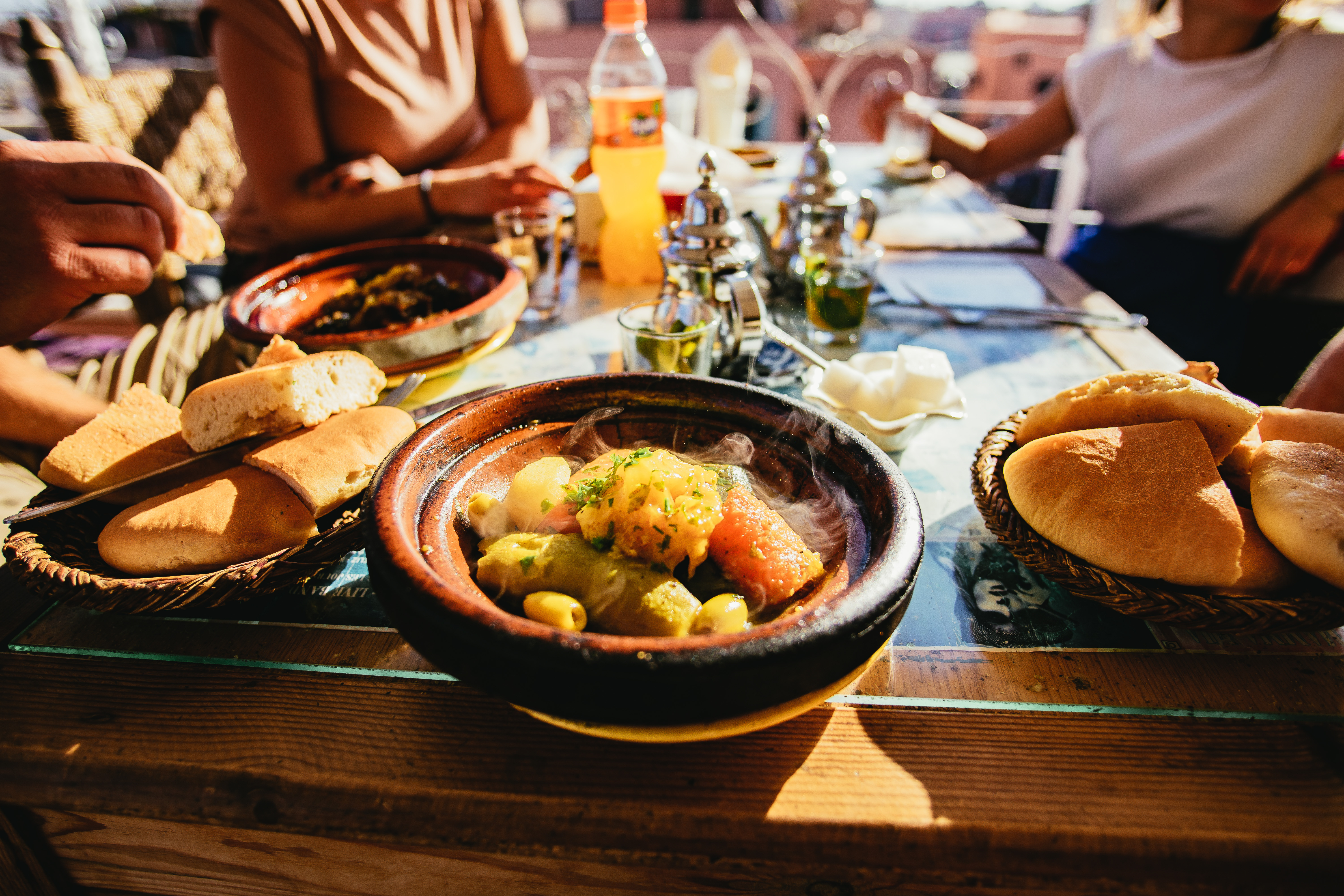 Marokkansk køkken med dampende tajine skål serveret på restaurant i Marrakesh
