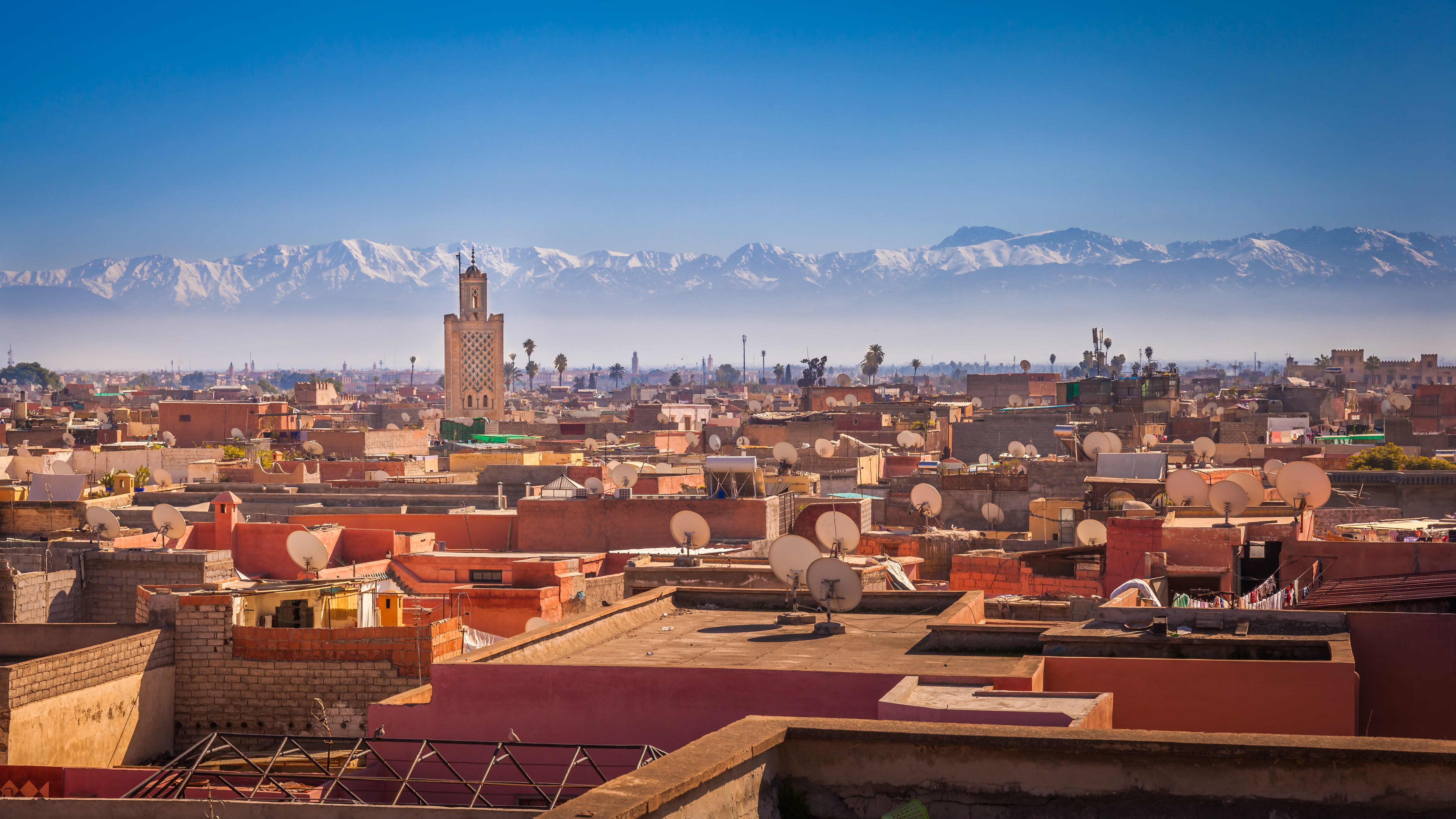 Storslået udsigt over den gamle by Marrakesh med dens minareter og de smukke sneklædte Atlasbjerge i det fjerne, Marokko