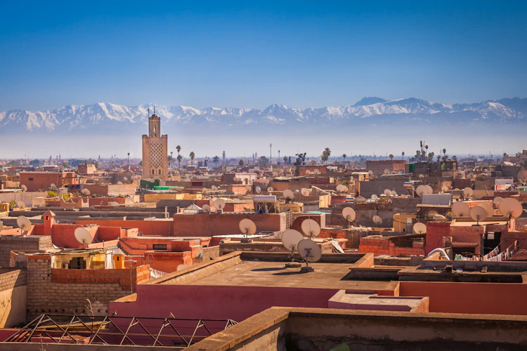 Storslået udsigt over den gamle by Marrakesh med dens minareter og de smukke sneklædte Atlasbjerge i det fjerne, Marokko