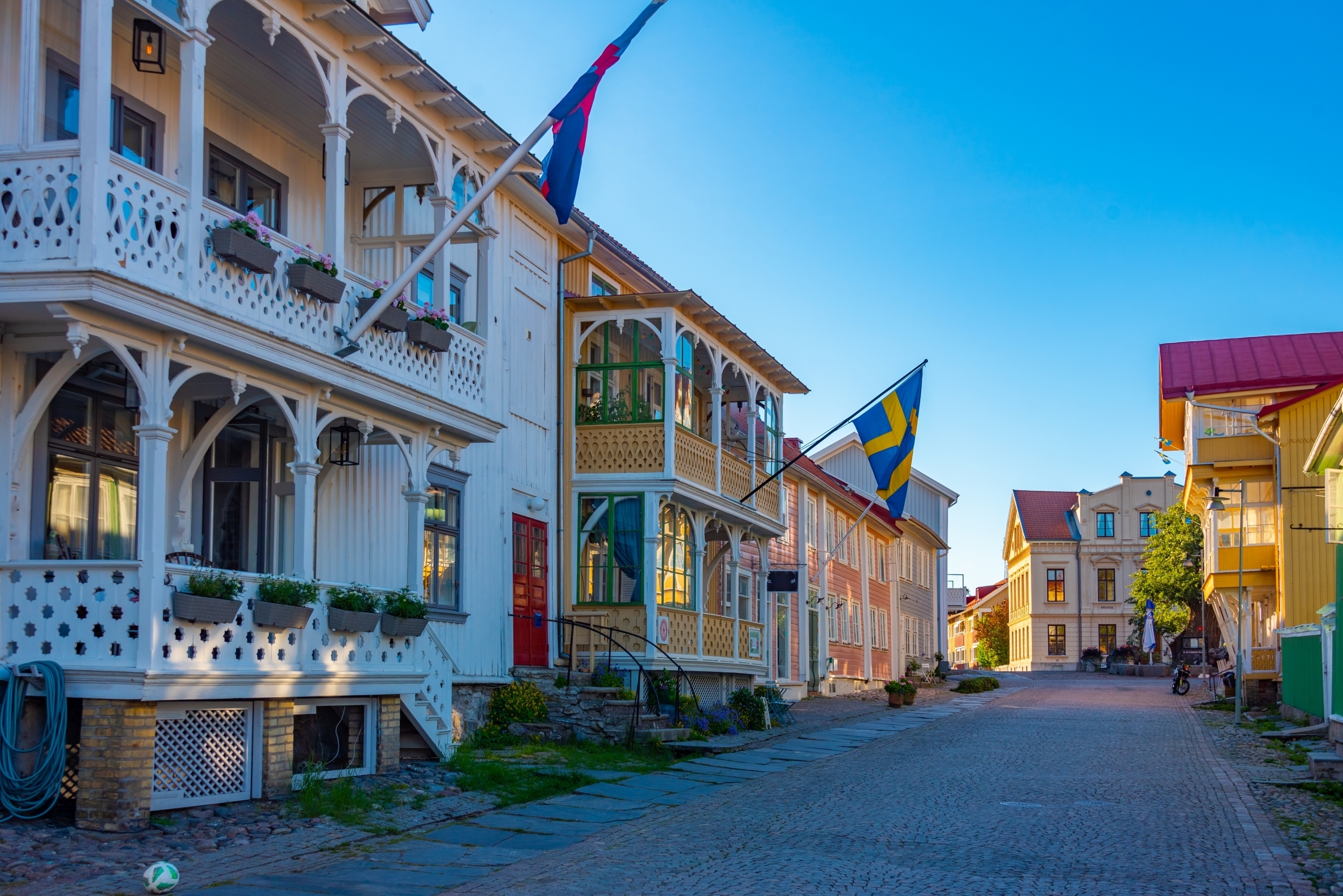 Idyllisk historisk gade i Marstrand på den svenske vestkyst med farverige træhuse og dekorative balkoner om sommeren