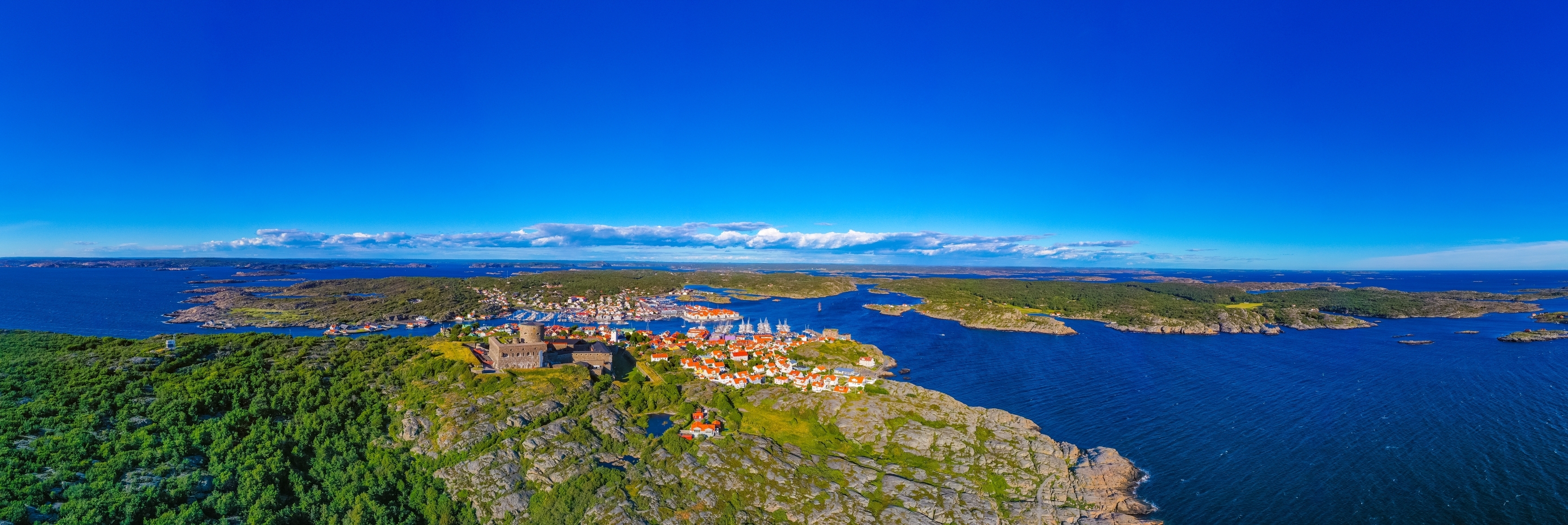 Luftfoto af Marstrand øen i det vestlige Sverige med den imposante Carlsten fæstning, charme­fulde havneby og sejlbåde i den svenske skærgård om sommeren