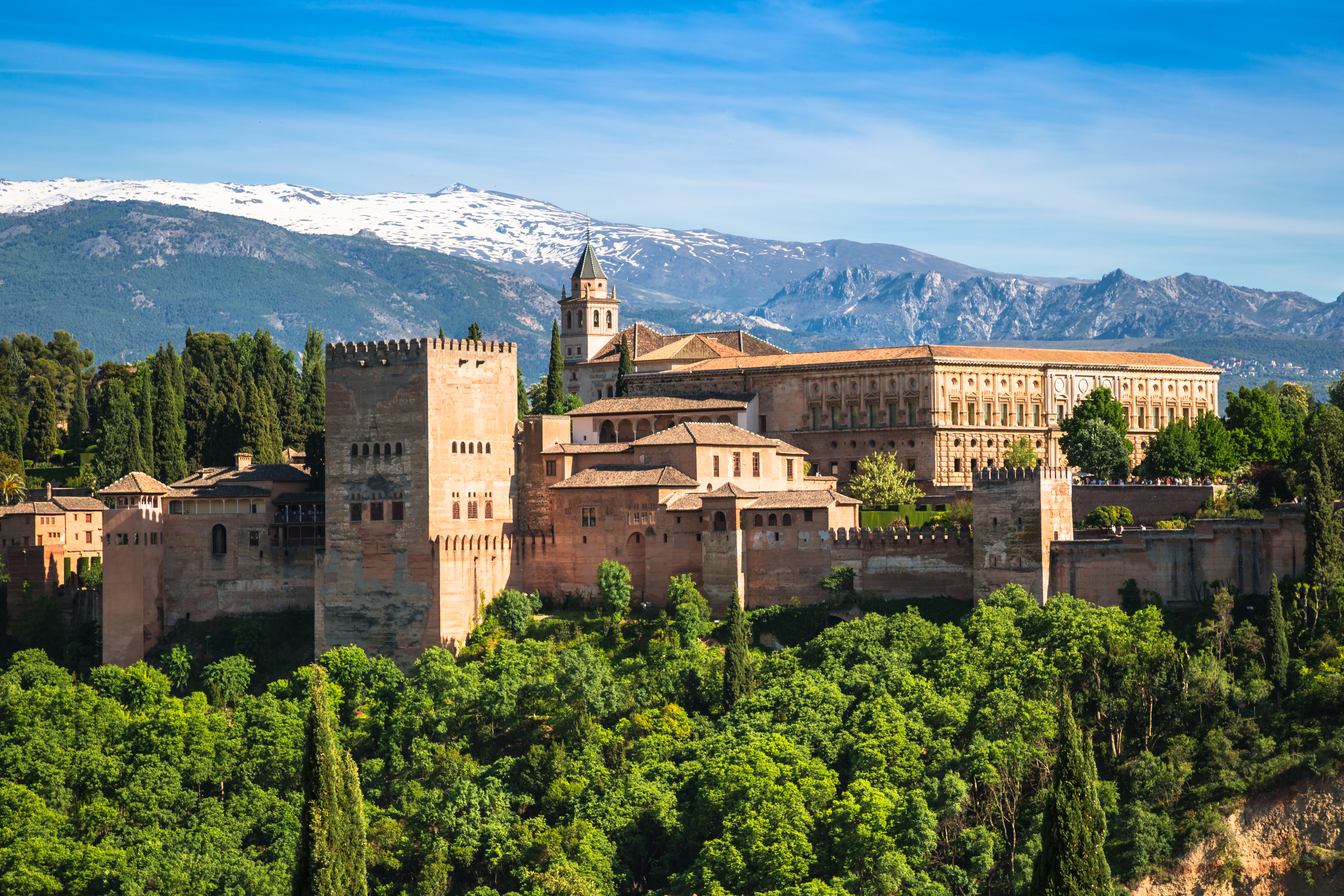 Det mauriske Alhambra palads i Granada omgivet af grønne træer og bjerge