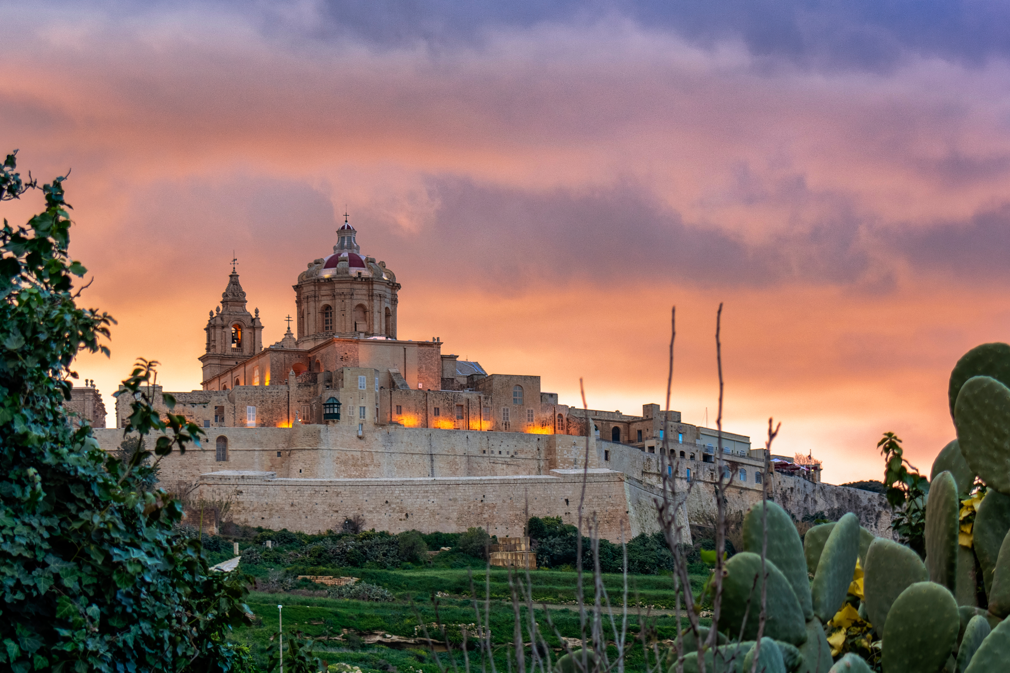 Mdinas imponerende katedral og bymure i gyldent aftenlys, Malta