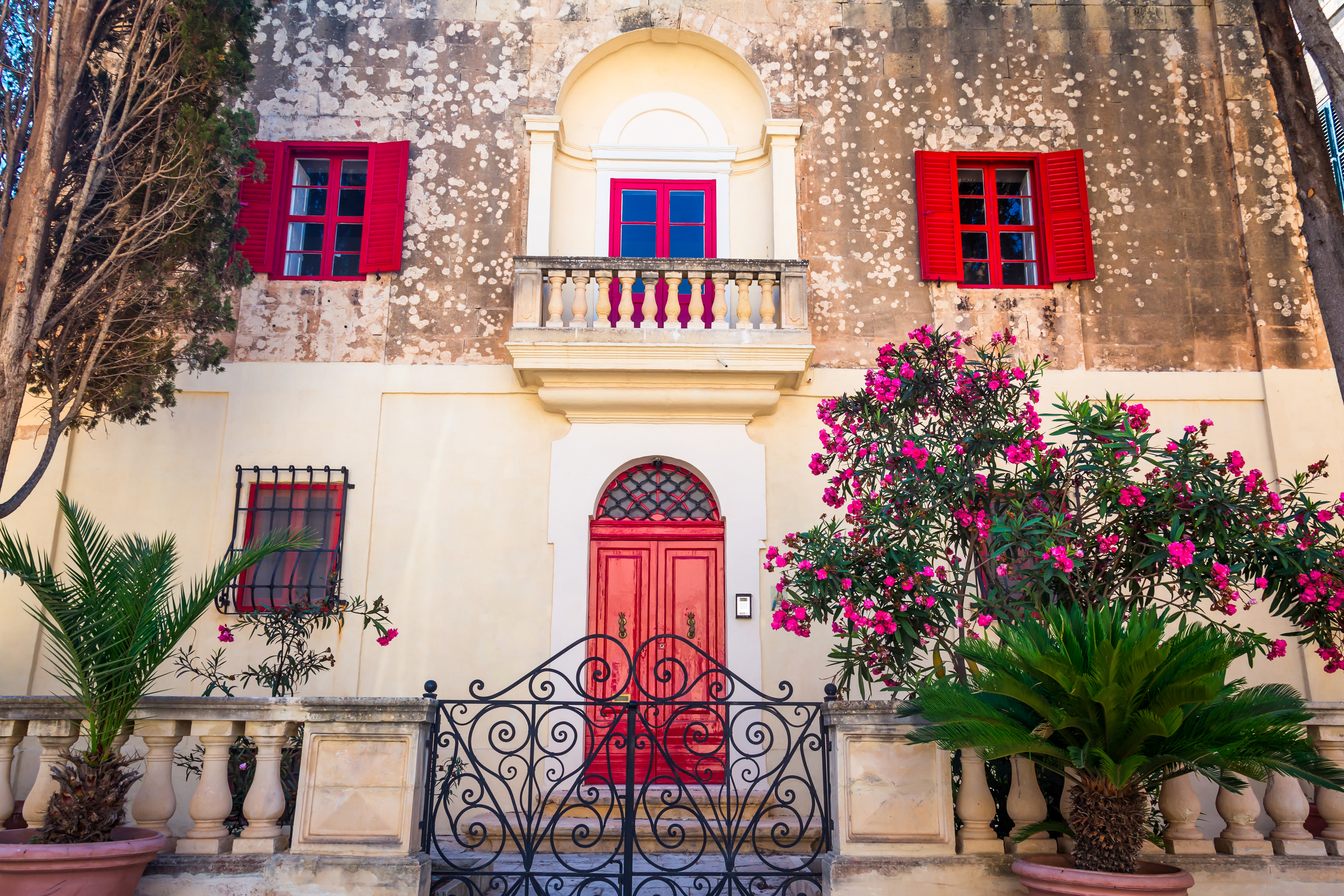 Middelalderlig bygning i Mdina Malta med blomstrende bougainvillea i haven