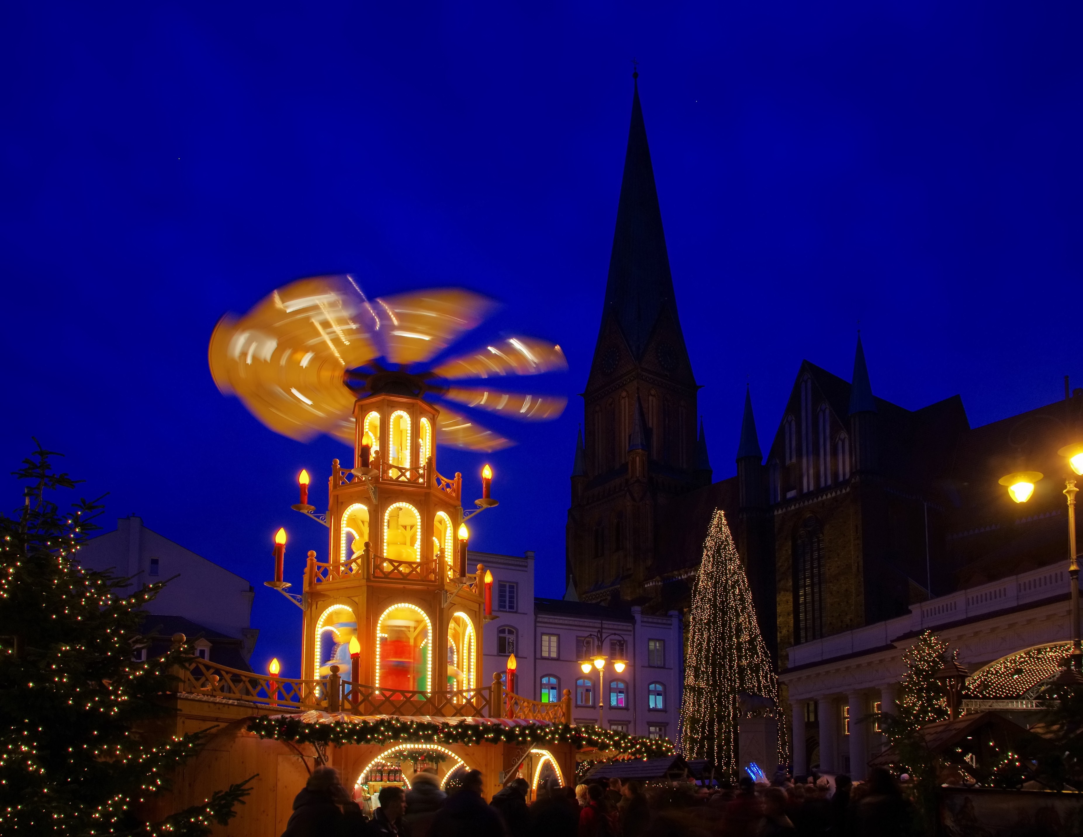 Tysk julemarked i Schwerin med traditionel julepyramide og oplyst katedral om aftenen