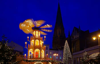 Tysk julemarked i Schwerin med traditionel julepyramide og oplyst katedral om aftenen