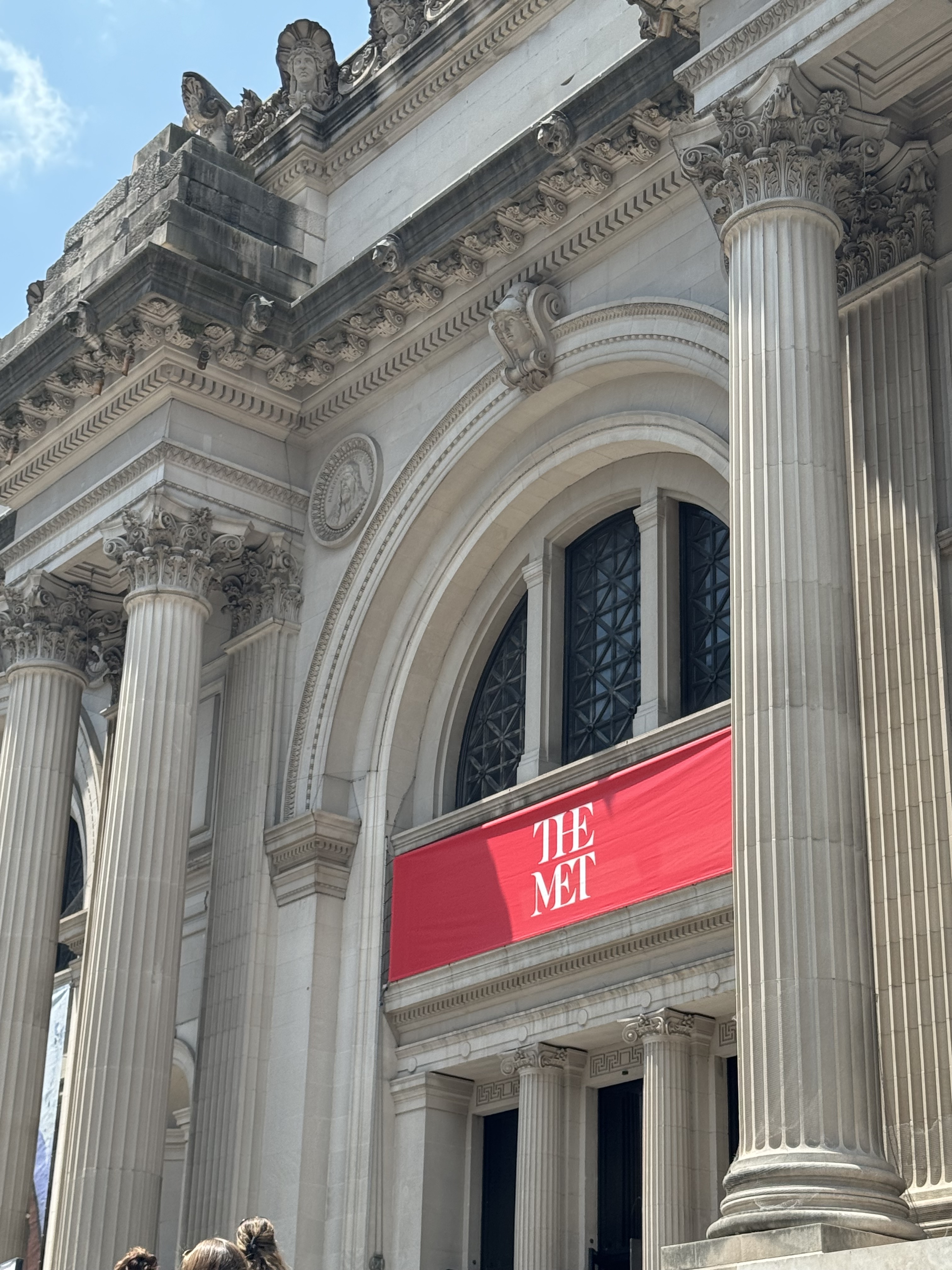 Indgangen til The Metropolitan Museum of Art i New York med karakteristiske søjler og rød The Met-skiltning