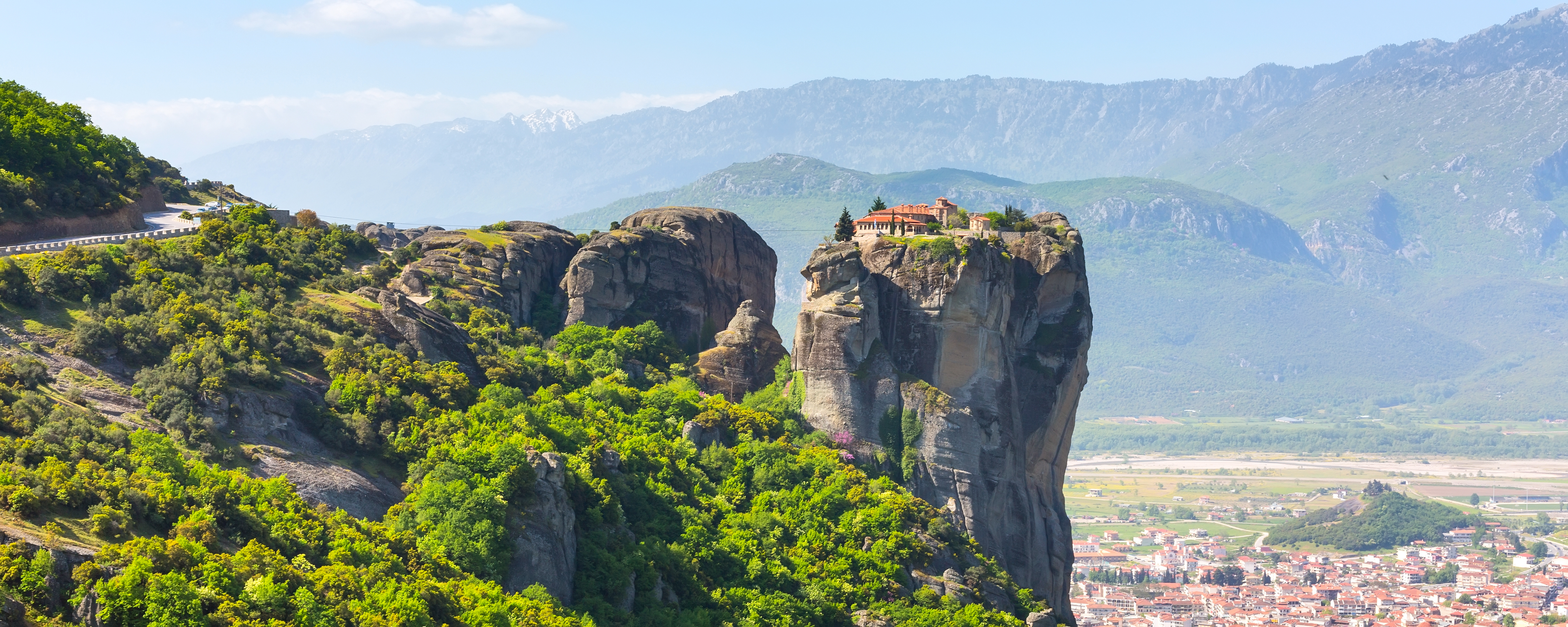 Ortodokst kloster thronende på høj klippe i Meteora med smuk udsigt over Kalambaka og det græske landskab