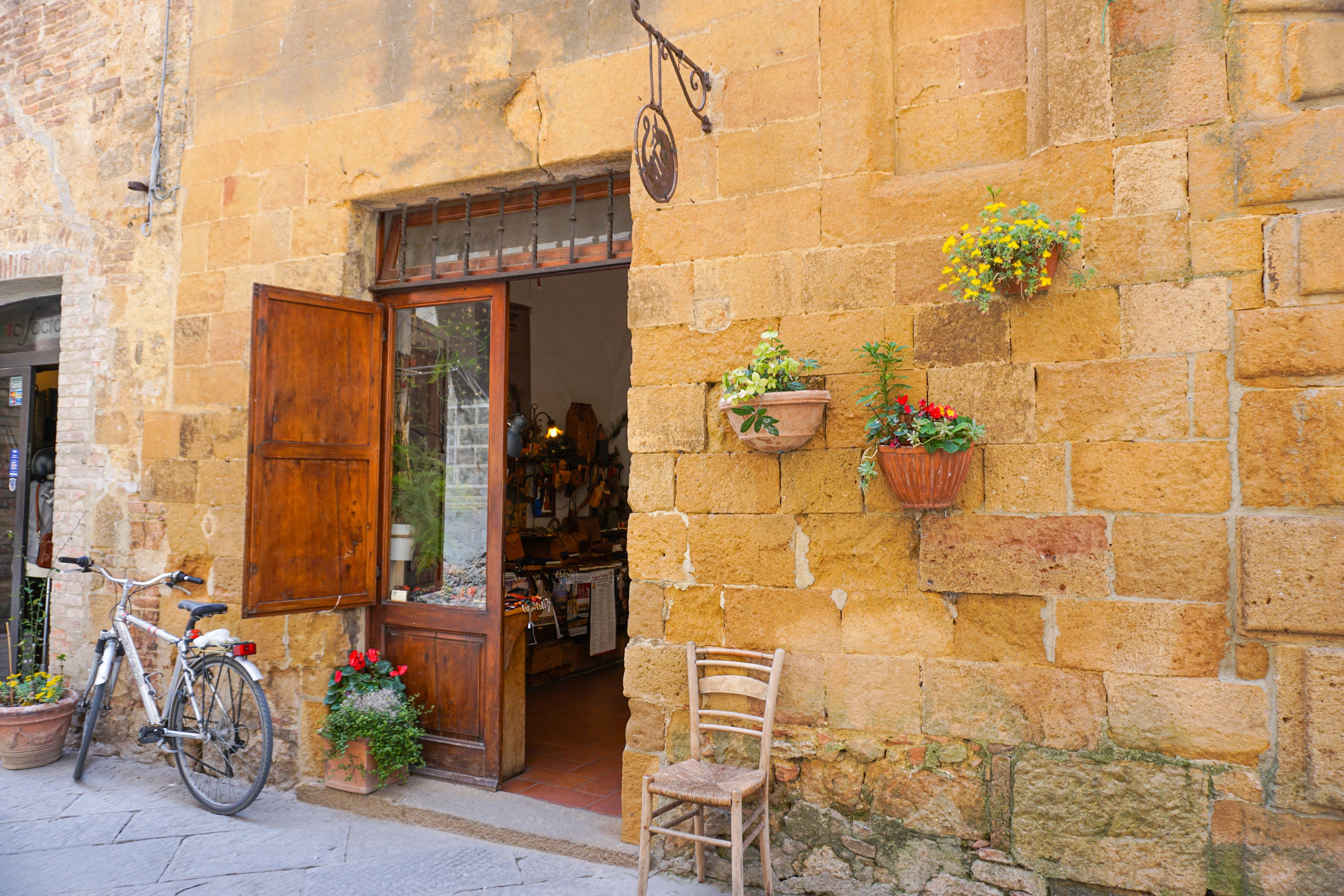Historisk italiensk bygade med middelalderarkitektur, cykel og dekorative blomster
