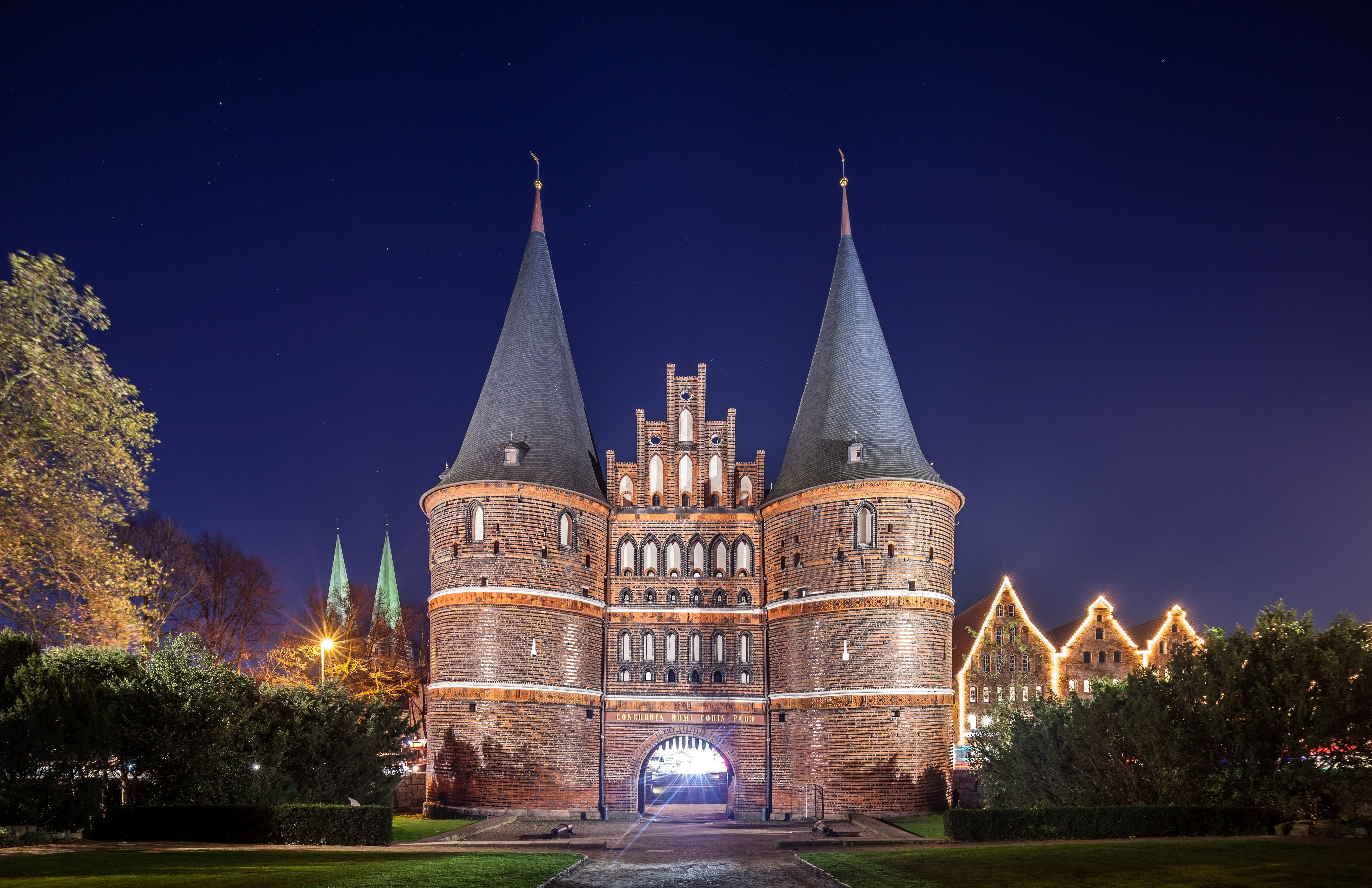 Ikonisk Holstentor fæstningsport i Lübeck med flot aftenlys og historisk tysk arkitektur