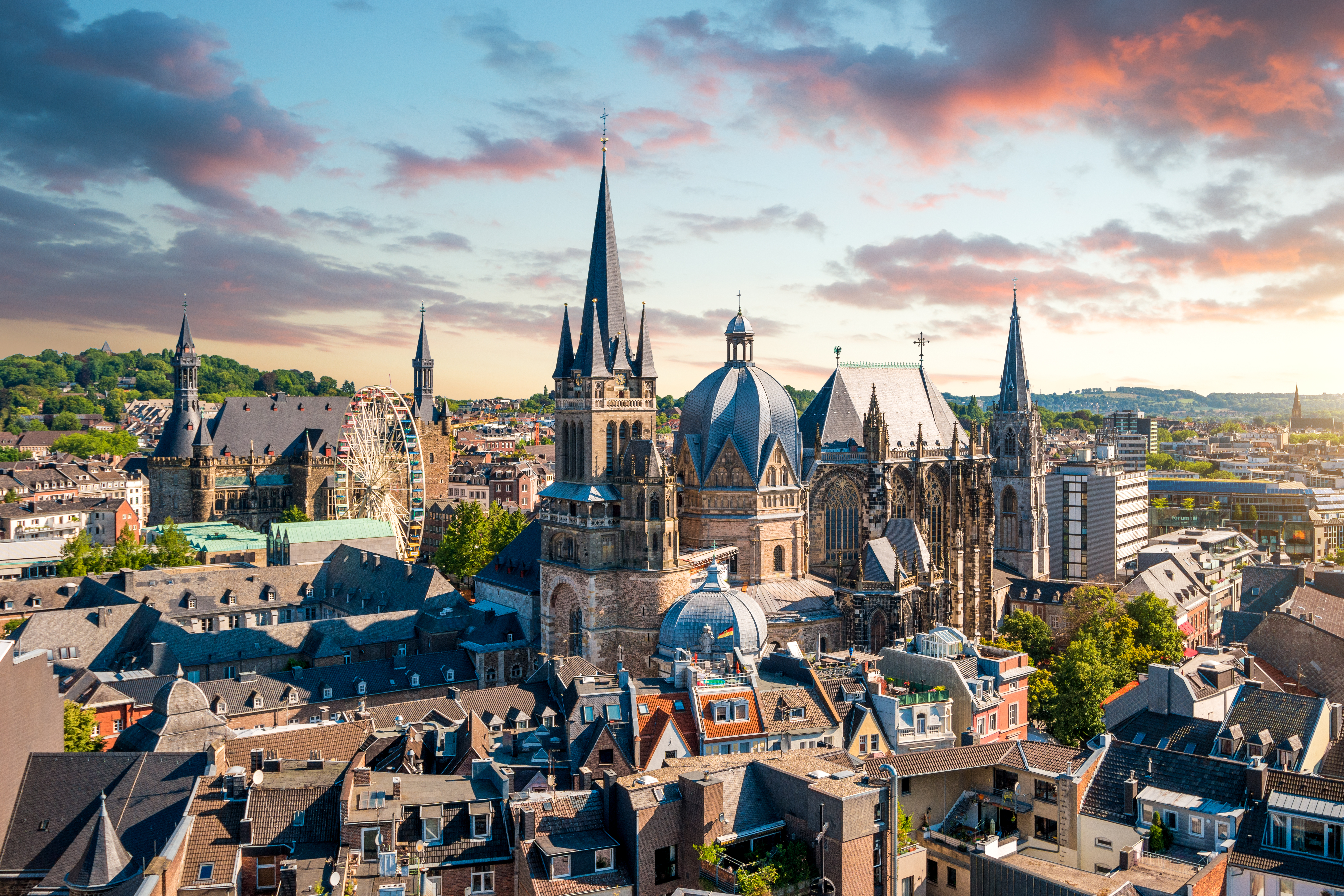 Middelalderlig katedral i Aachen set fra luften med farverige aftenhimmel
