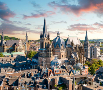Middelalderlig katedral i Aachen set fra luften med farverige aftenhimmel