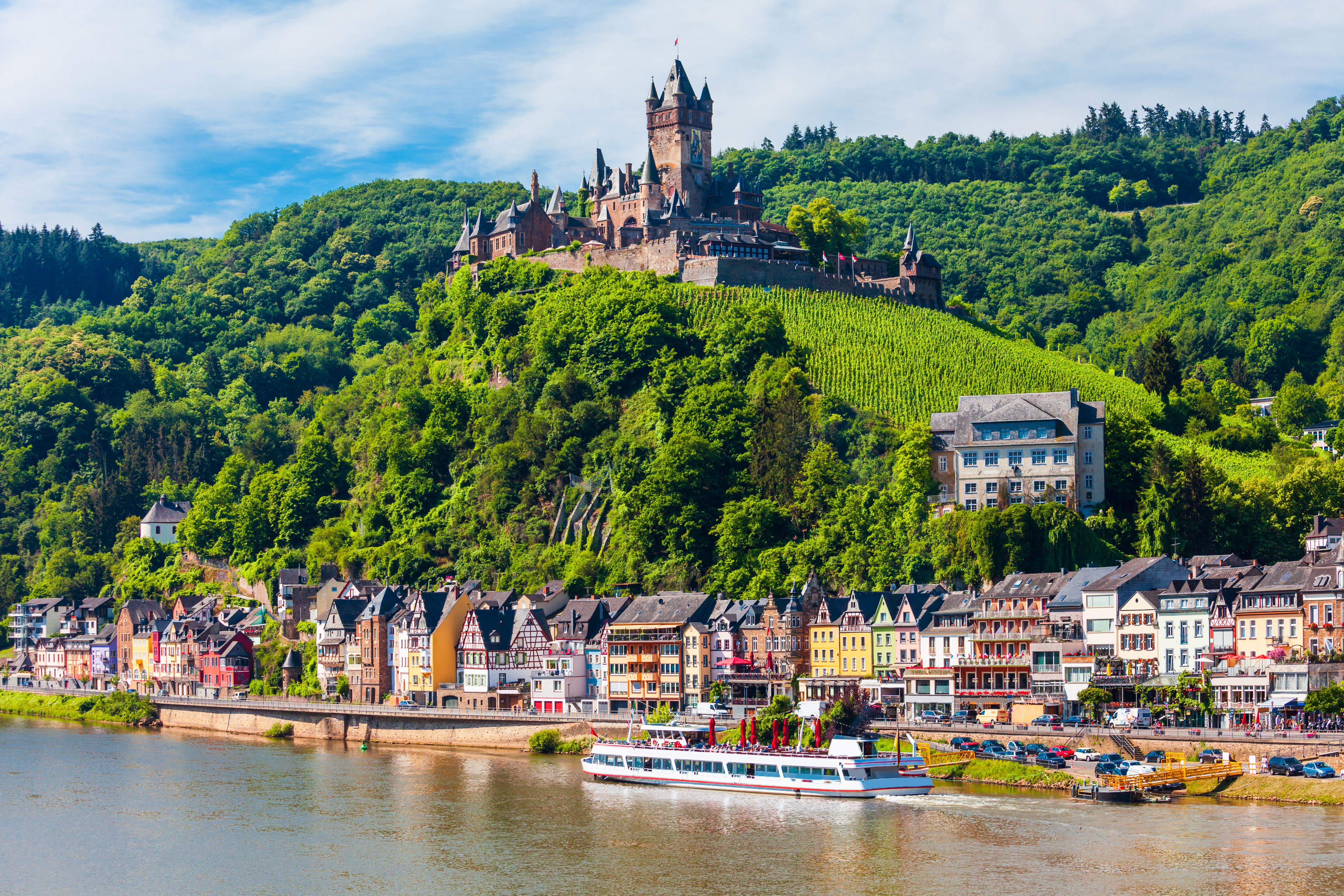 Det imponerende Reichsburg slot fra middelalderen knejser over Cochem by og den idylliske Mosel-dal med vinmarker i Tyskland