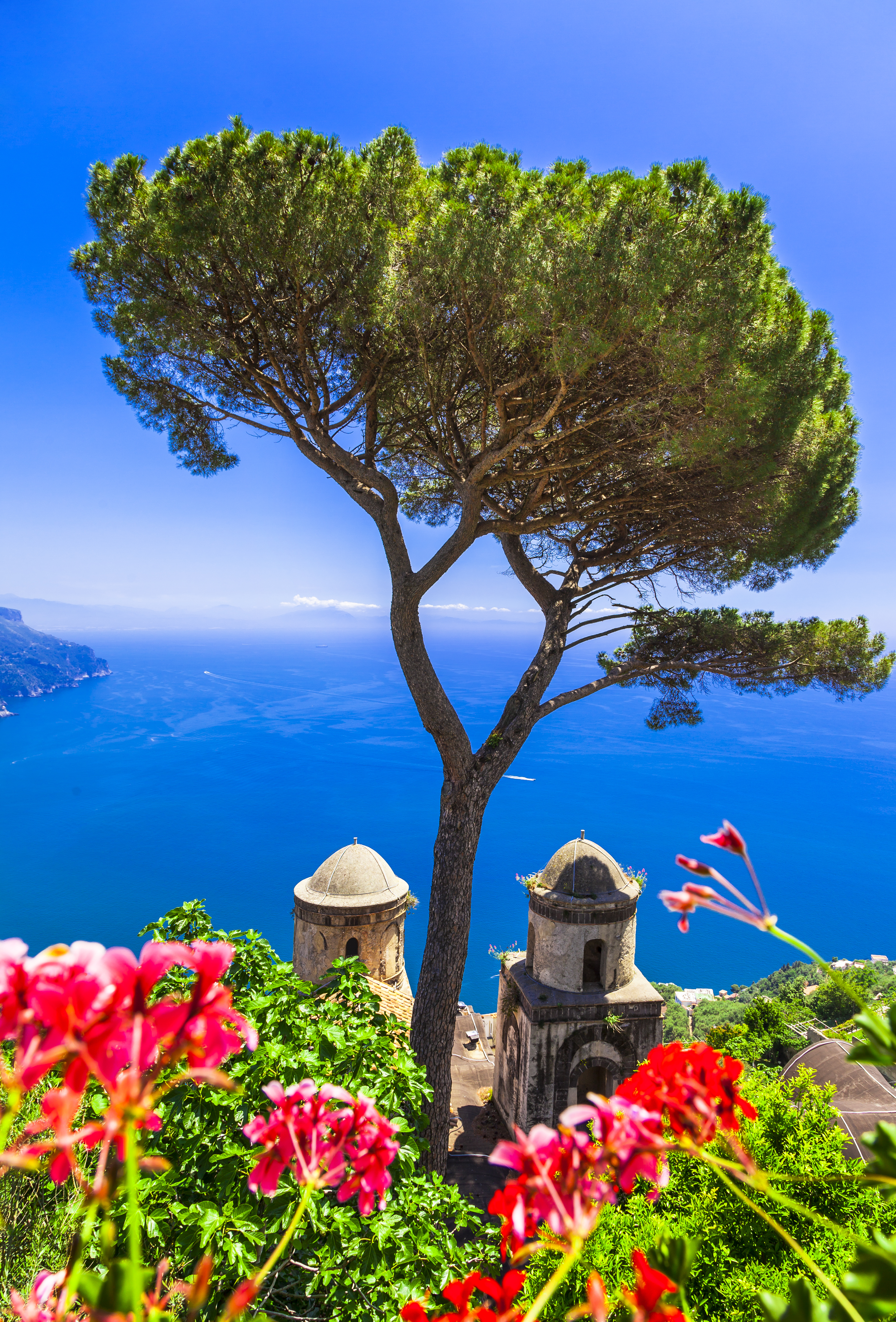 Spektakulær udsigt over Amalfi-kysten med historiske bygninger og blomstrende have