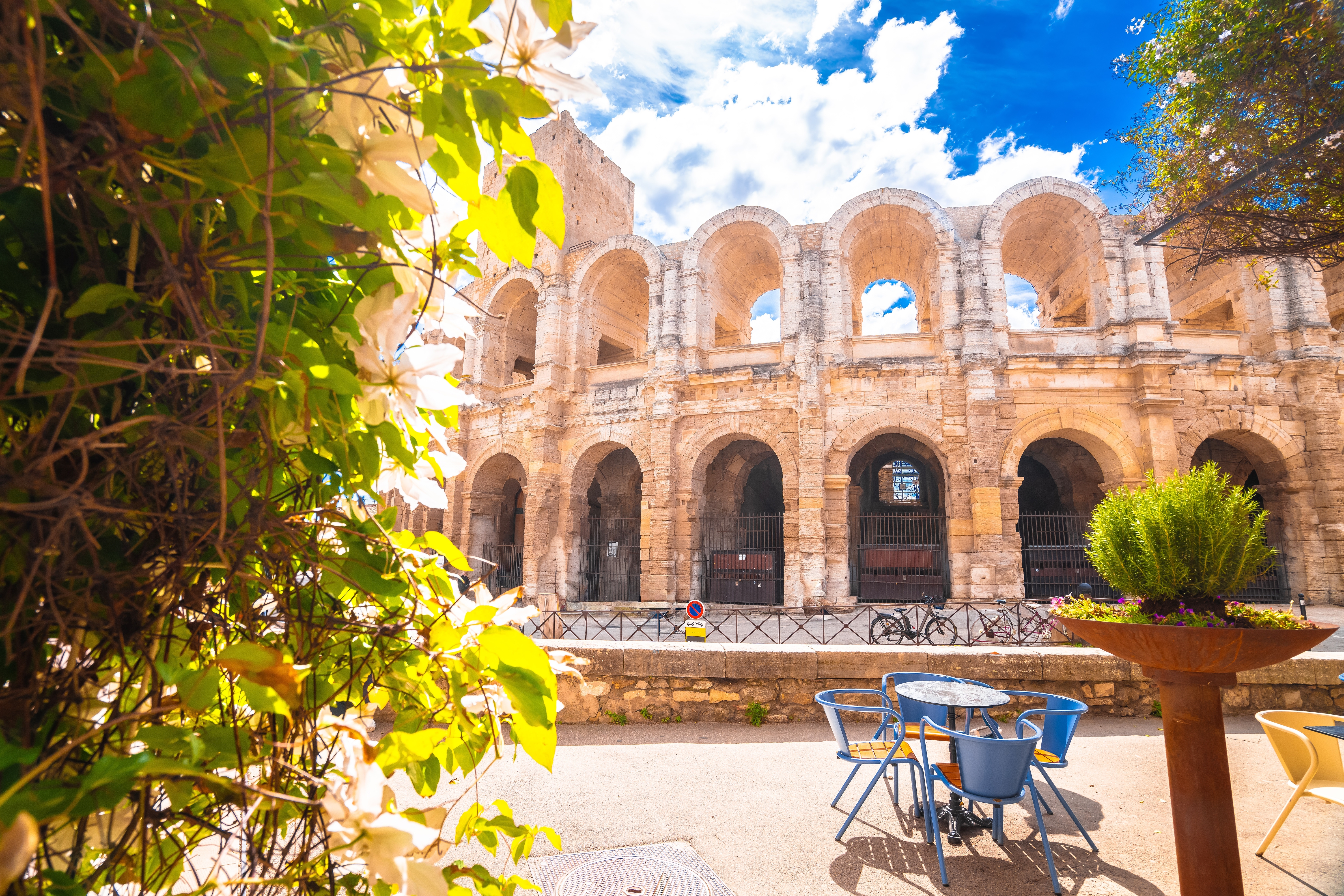 Middelhavsstemning ved det gamle amfiteater i Arles med terrasse og blå stole