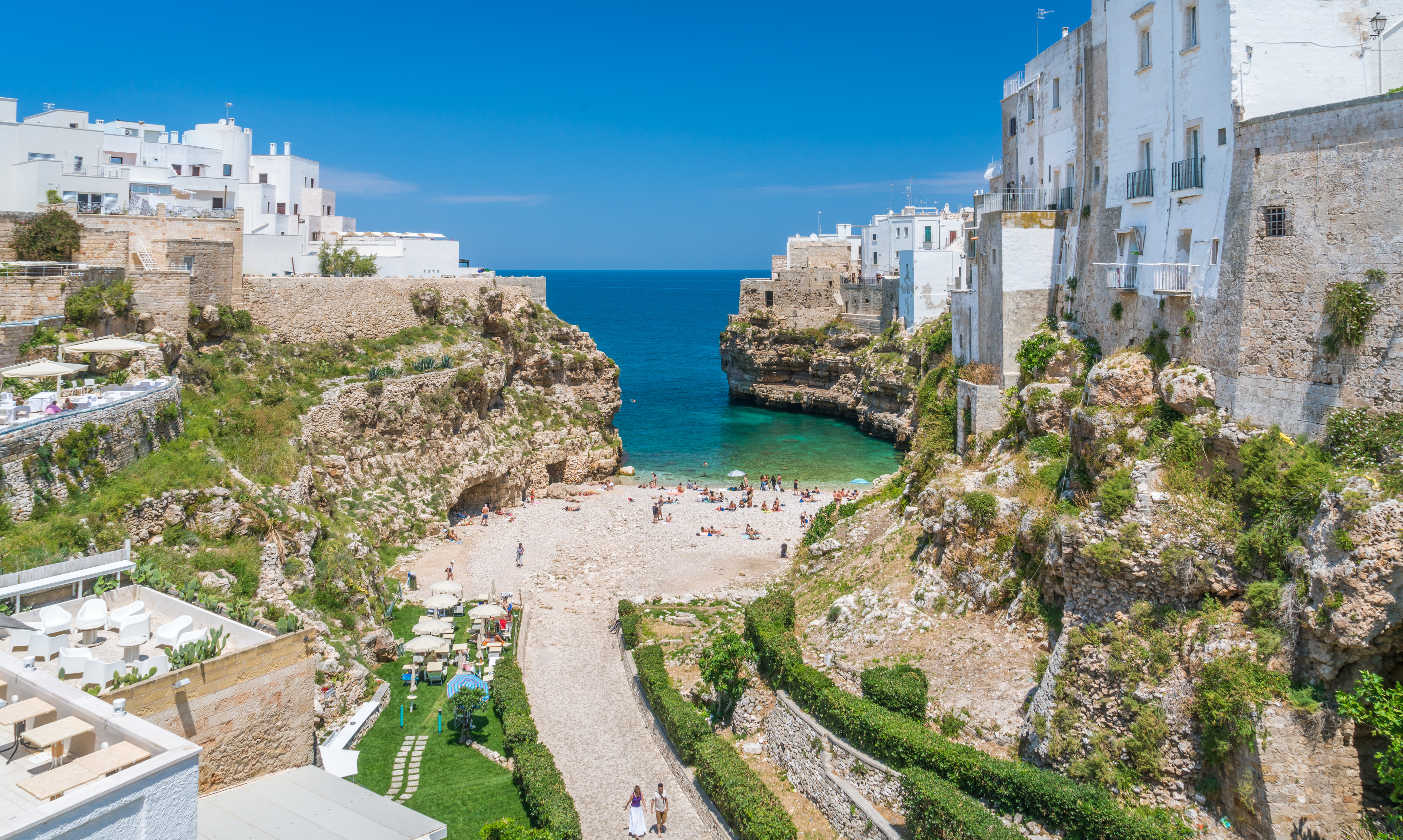 Polignano a Mare strand med turkisblåt vand og traditionel italiensk arkitektur i Puglia