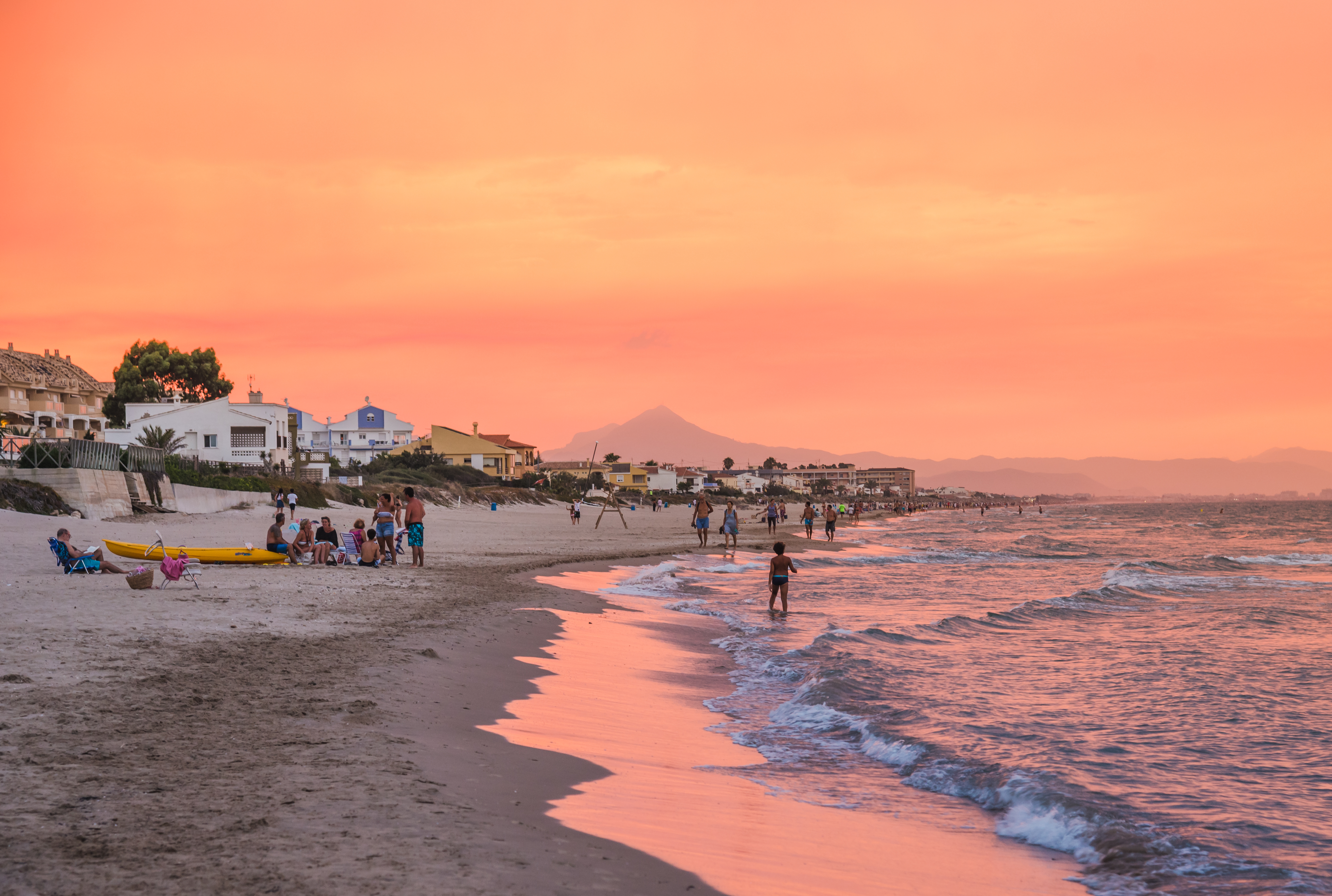 Romantisk solnedgang ved Middelhavet på Costa Blanca med orange himmel og strandliv