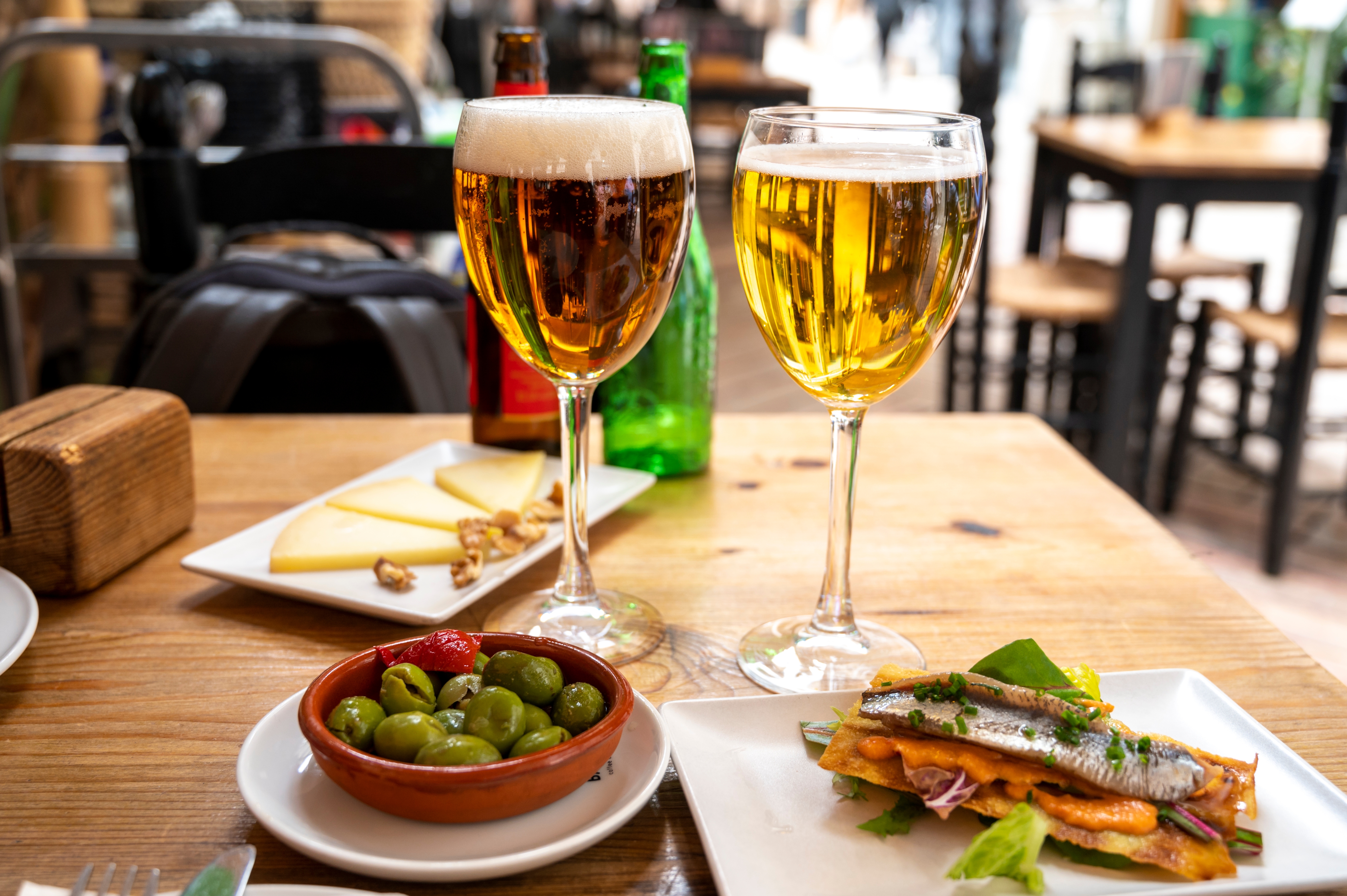 Middelhavsferie med øl og tapas - grønne oliven og anchovy sandwich på lokal restaurant