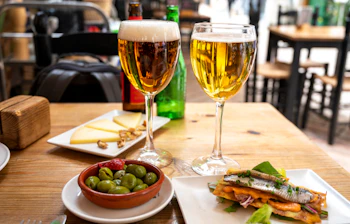 Middelhavsferie med øl og tapas - grønne oliven og anchovy sandwich på lokal restaurant