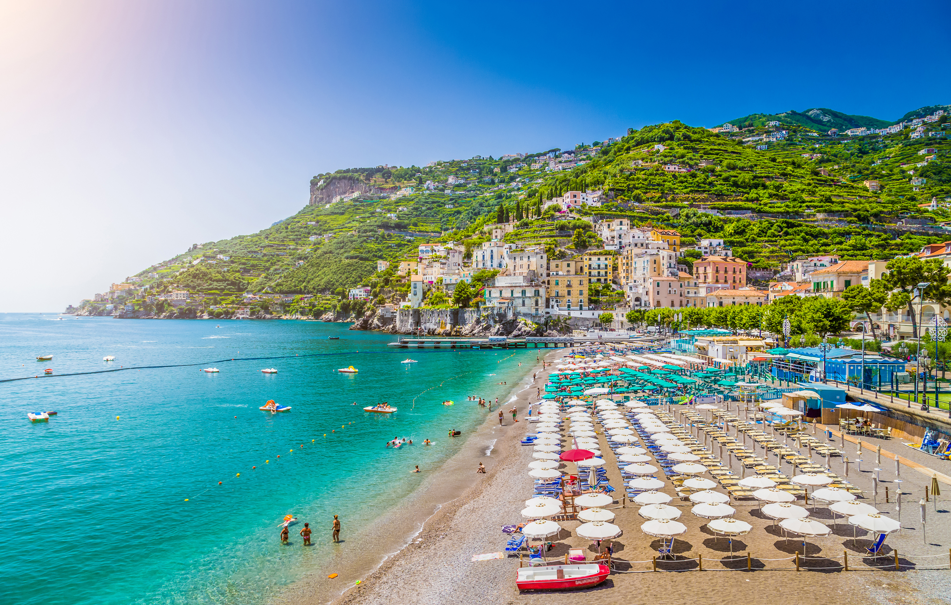 Fantastisk udsigt over Middelhavsstrand ved Amalfi-kysten med traditionelle italienske huse og solparasoller