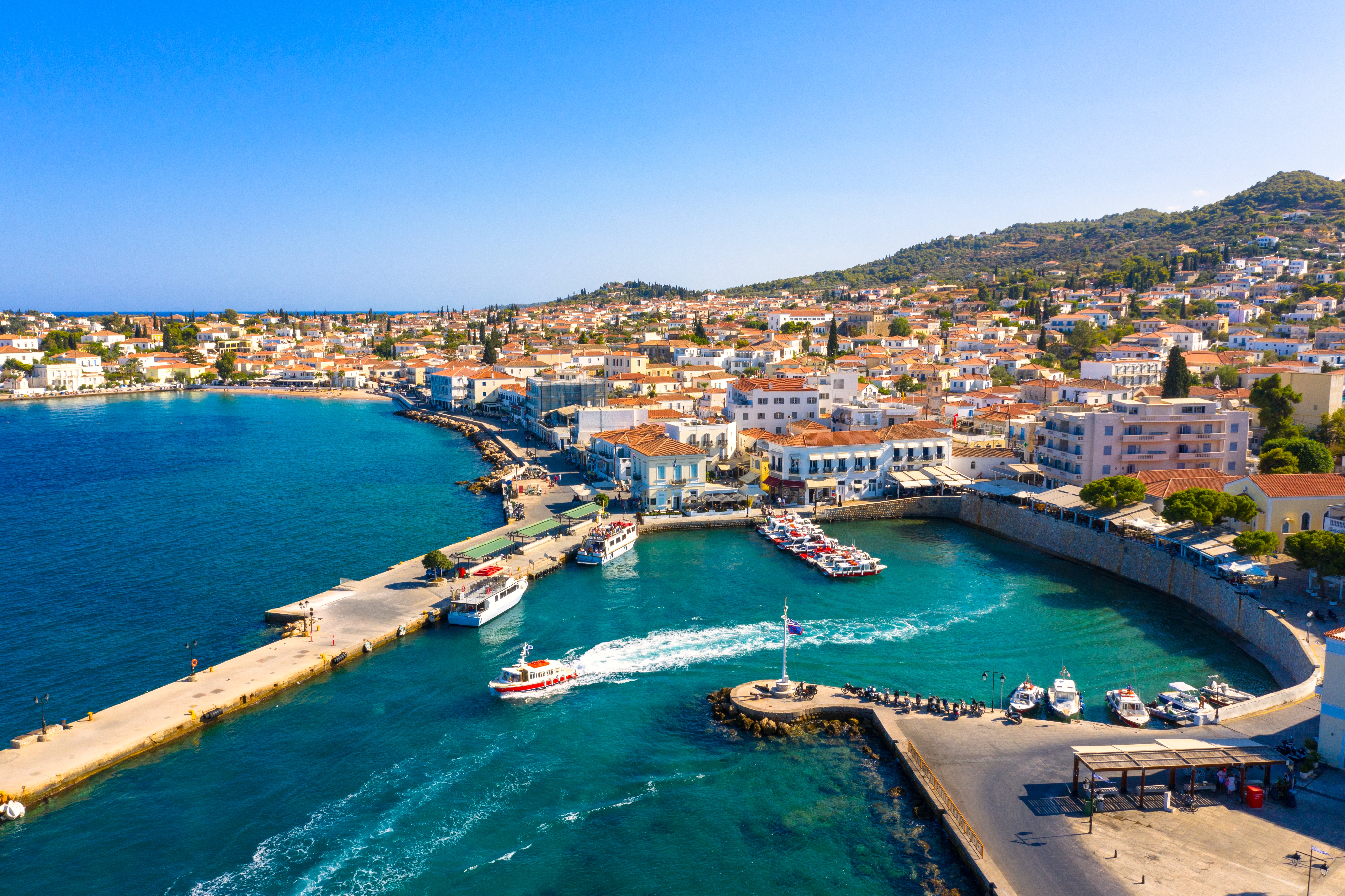 Smuk middelhavshavn på Spetses med traditionelle græske huse og turkisblåt vand