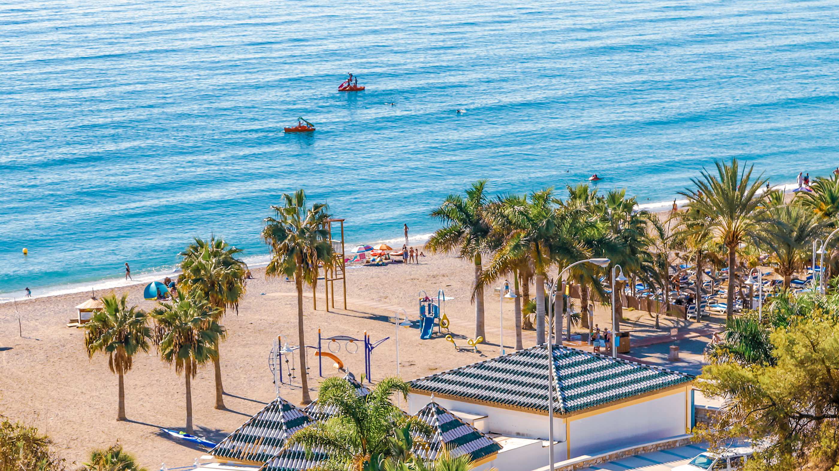 Skøn strand med palmer og både ved Middelhavet i Nerja Spanien