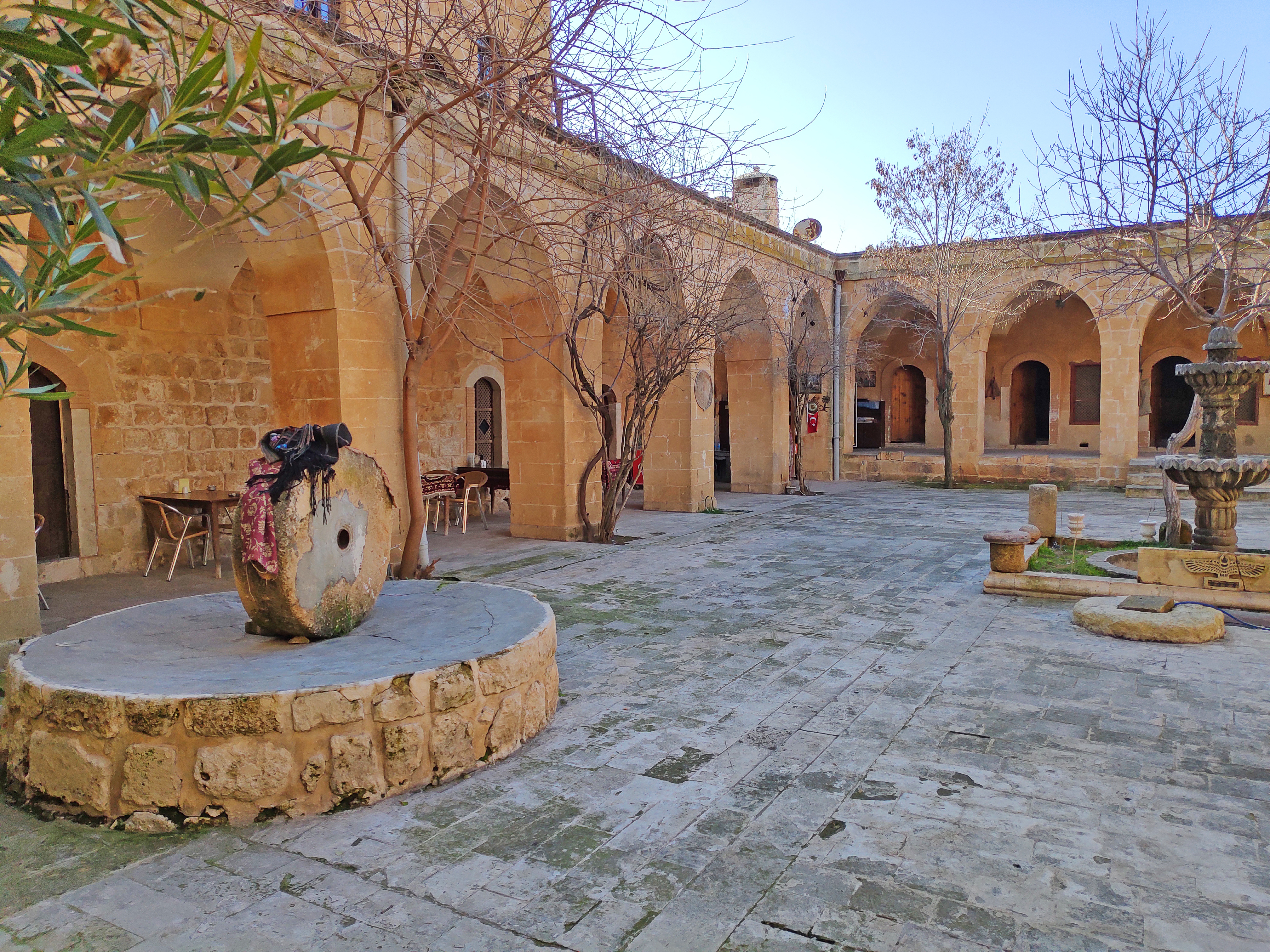 Historisk klostergård i Midyat nær Mardin i Tyrkiet med traditionelle stenbuer og gammel brønd fra den syrisk-ortodokse kultur