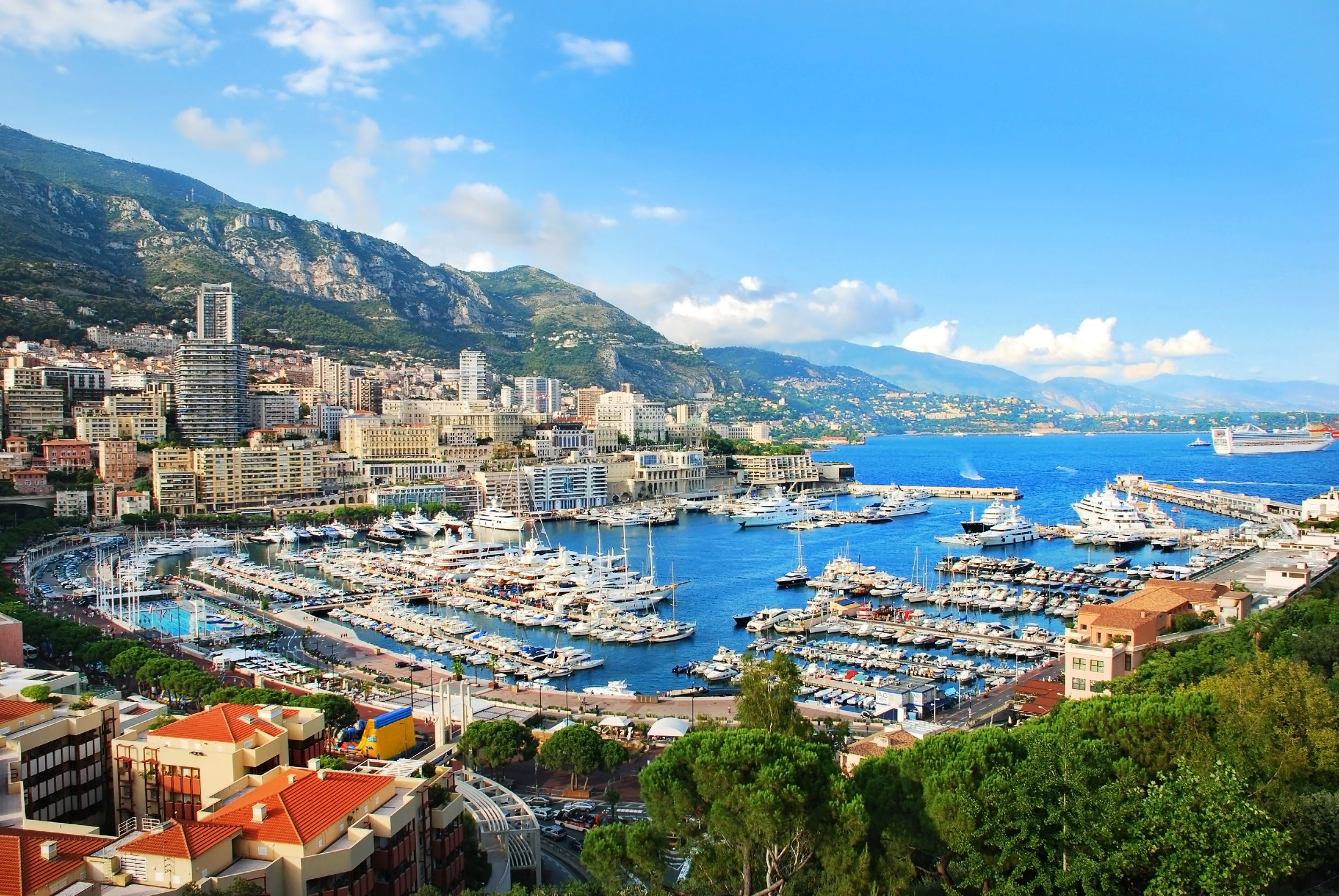 Imponerende udsigt over Monte Carlos havn i Monaco med eksklusive yachter, elegante bygninger og den smukke middelhavskystvej