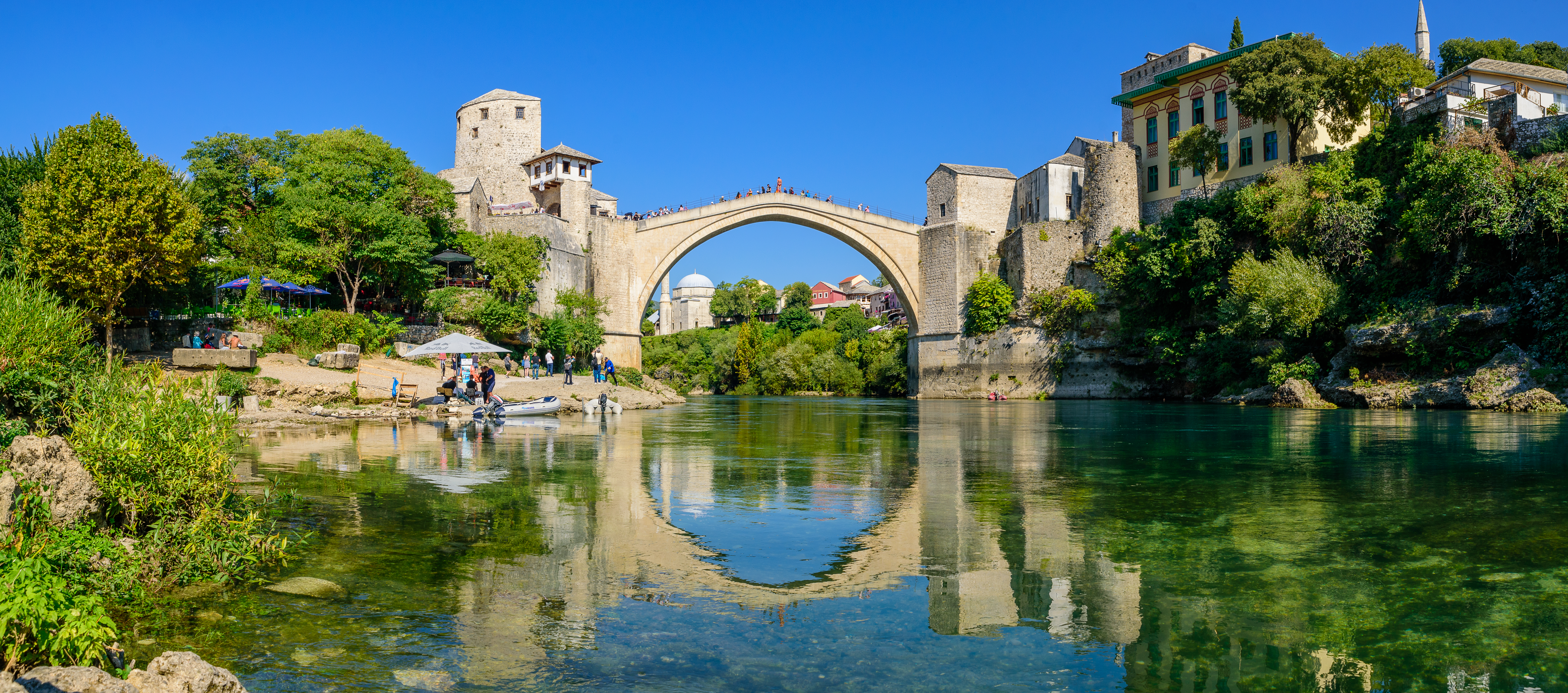 Middelalderlig stenbro i Mostar Bosnien med turkis flod og historisk arkitektur