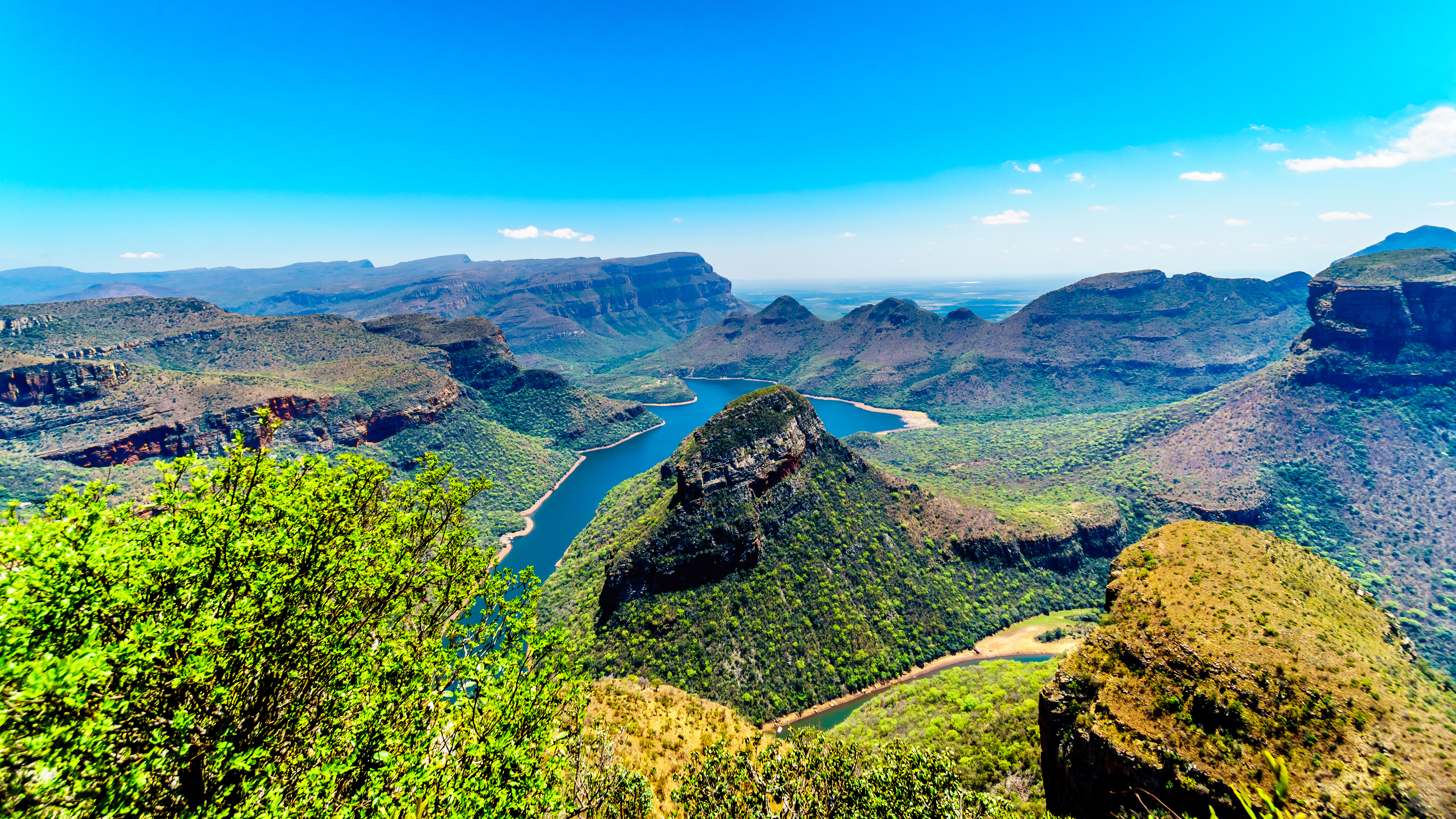 Fantastisk panoramaudsigt over det grønne Blyde River Canyon i Mpumalanga, Sydafrika, med den bugtende floddam omgivet af majestætiske bjerge og frodig natur