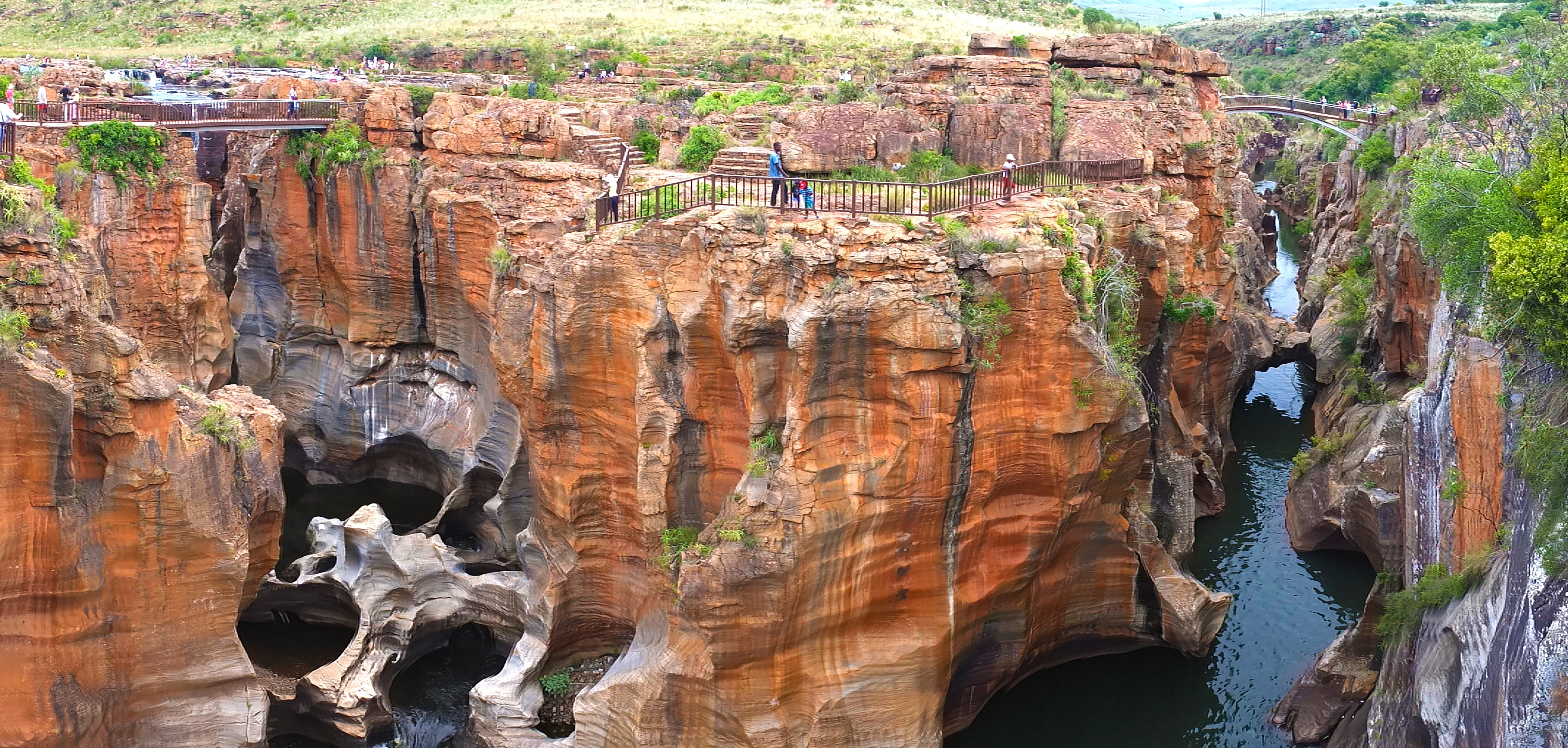 Geologiske Bourke's Luck Potholes med charakteristiske røde klipper og smaragdgrønne vandhuller i Mpumalanga