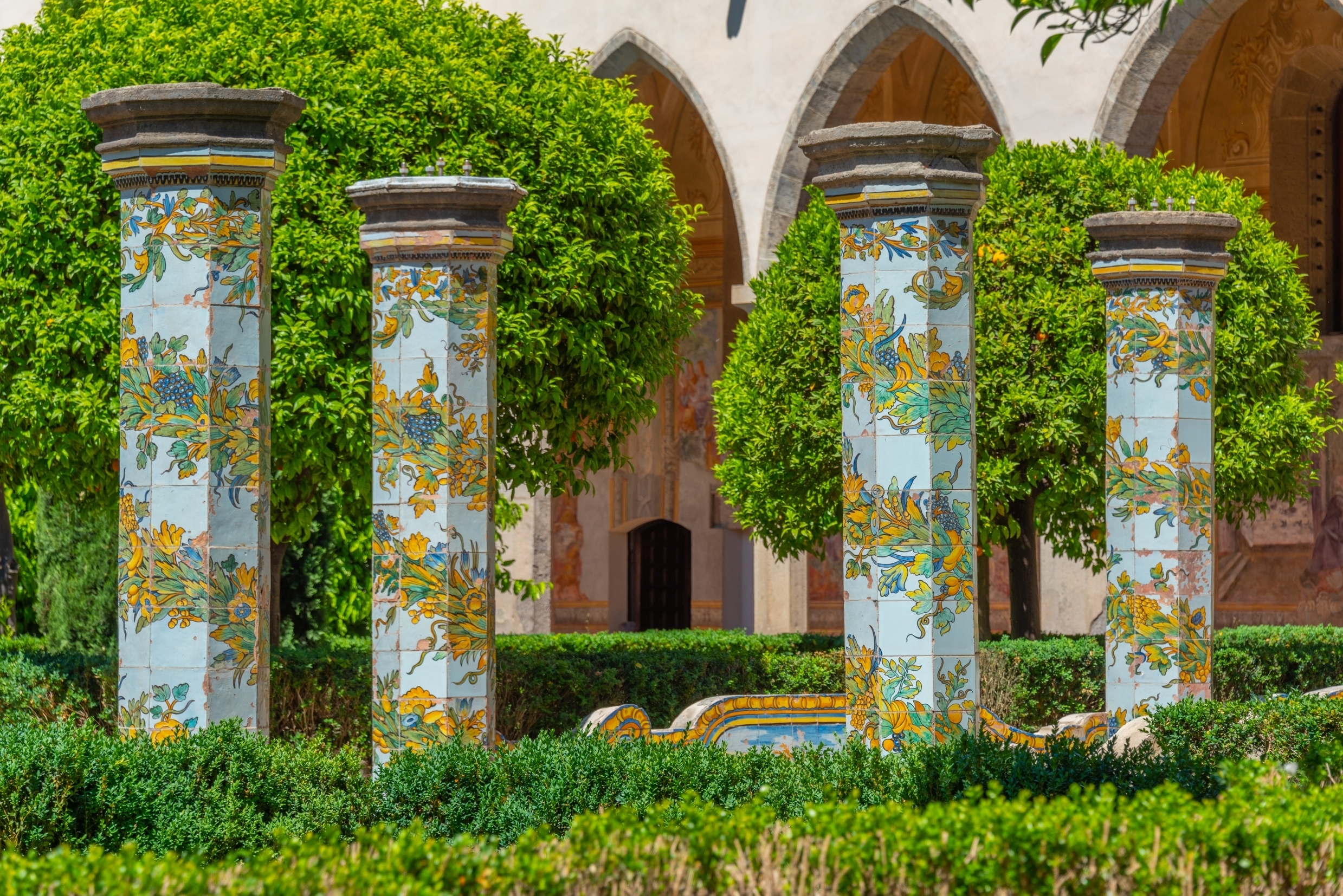 Ikoniske farverige søjler med blomstermønstre i majolica-fliser i Santa Chiara klosteret i Napoli, Italien