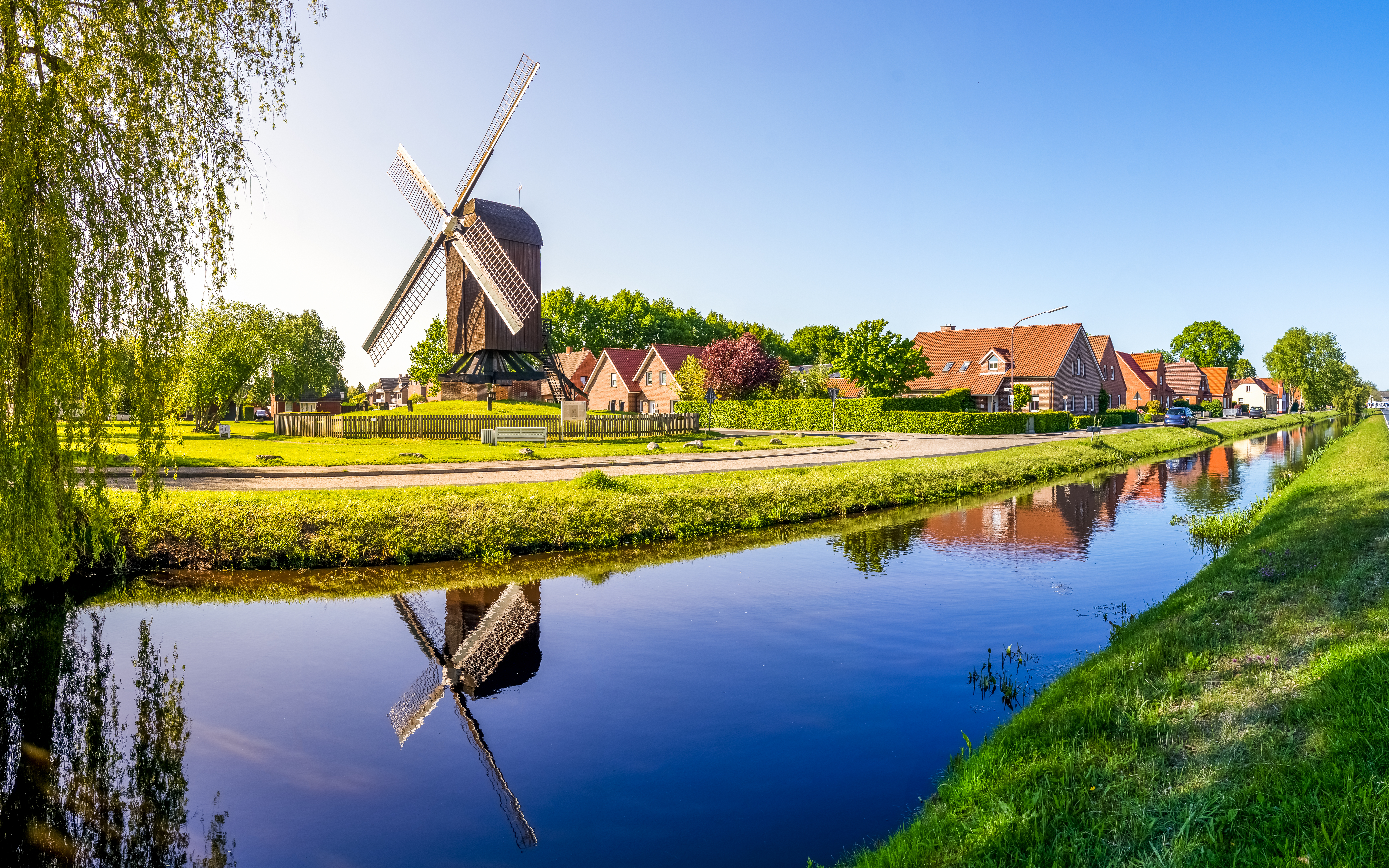 Autentisk nederlandsk vindmølle landskab med kanal reflektion og traditionelle bygninger