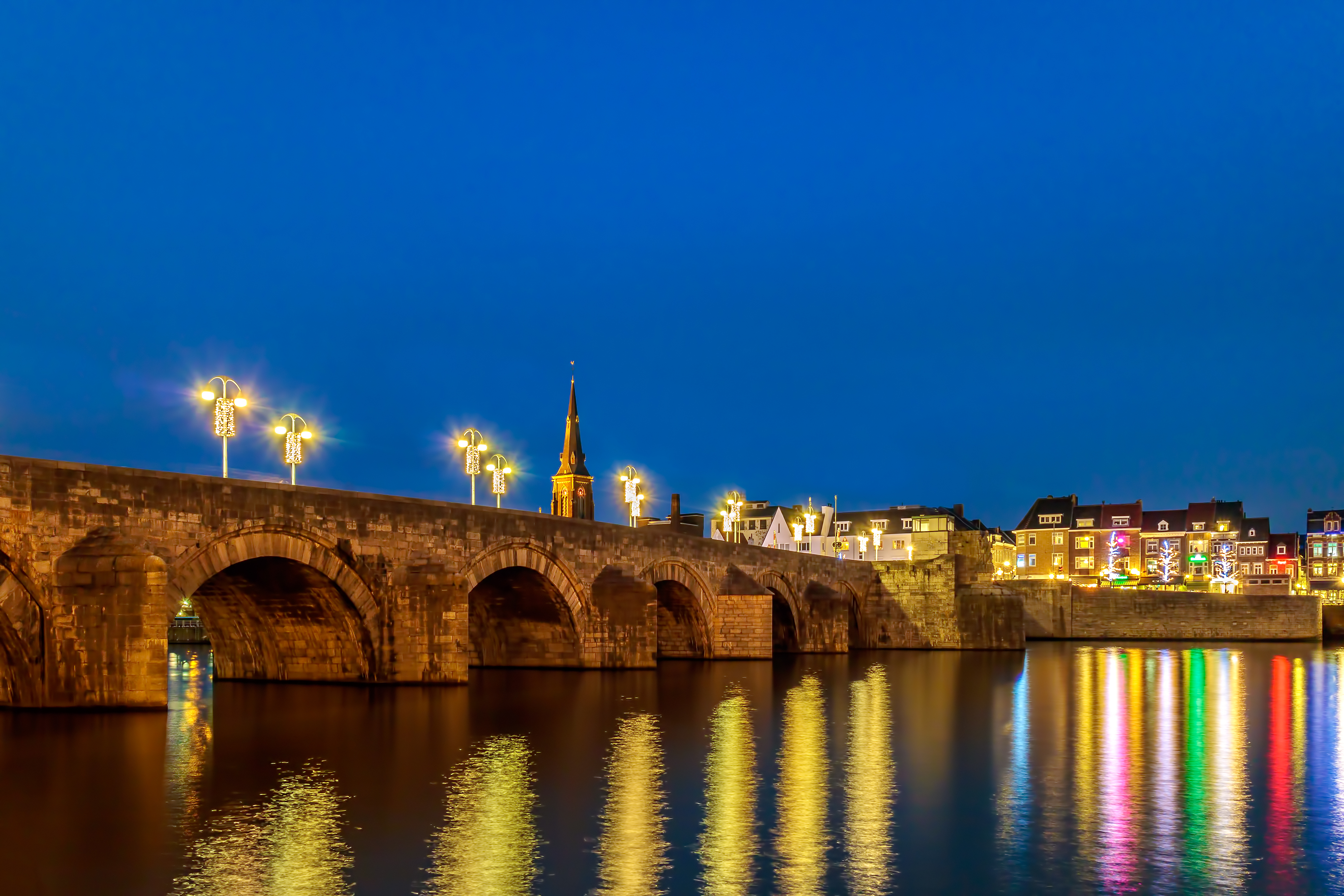 Maastricht bybro om natten i Limburg Nederland med lysrefleksioner i floden