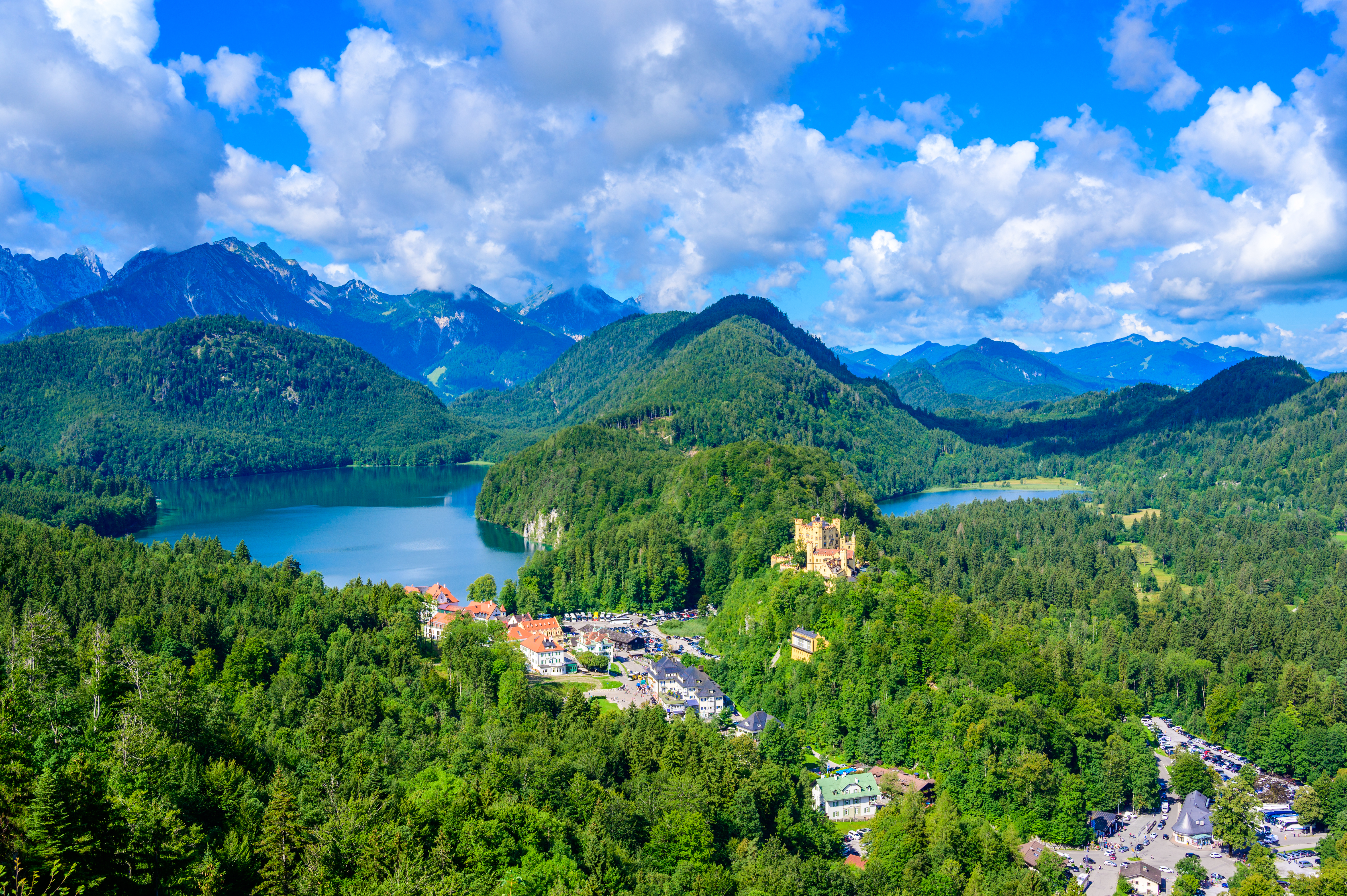 Spektakulær luftudsigt over Hohenschwangau Slot ved Alpsee og Schwansee omgivet af grønne skove og dramatiske alpebjerge i Allgäu-regionen i Bayern, Tyskland