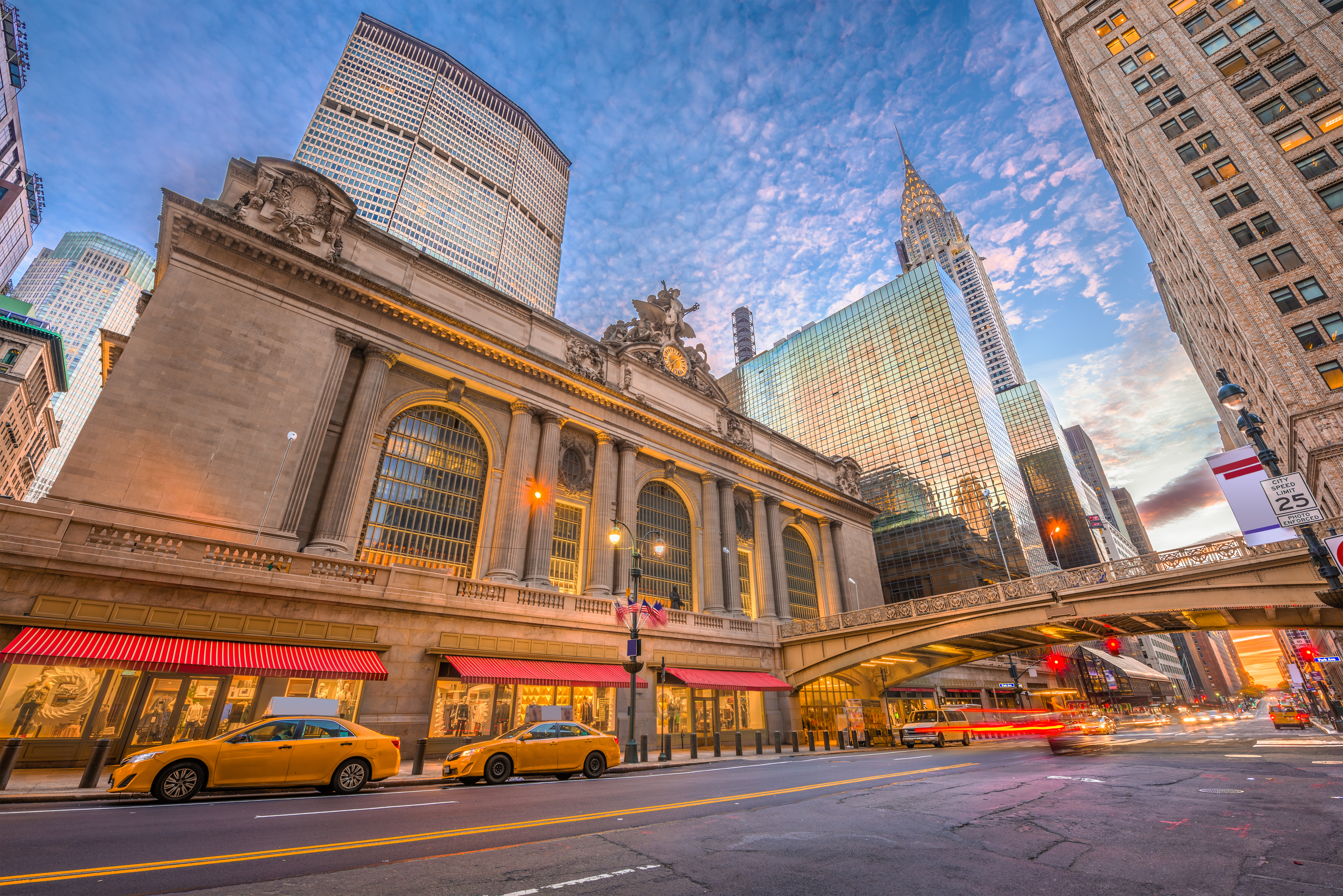 Ikonisk Grand Central Terminal i New York City med travl bygade, gule taxaer og imponerende skyskrabere i Midtown Manhattan