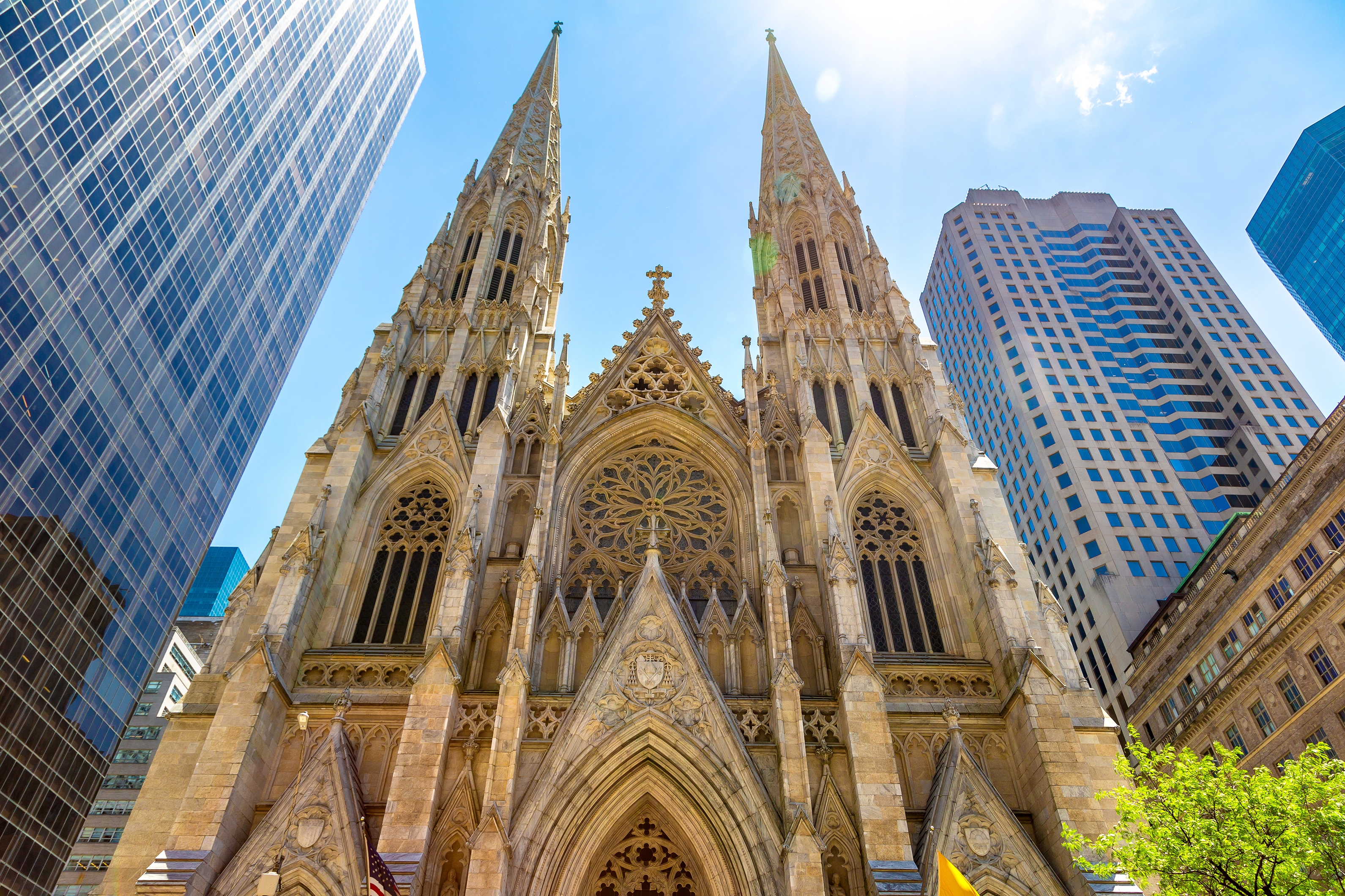 Majestætisk udsigt til St. Patricks Cathedral på Fifth Avenue i New York City med gotiske spir der rager op mellem moderne skyskrabere