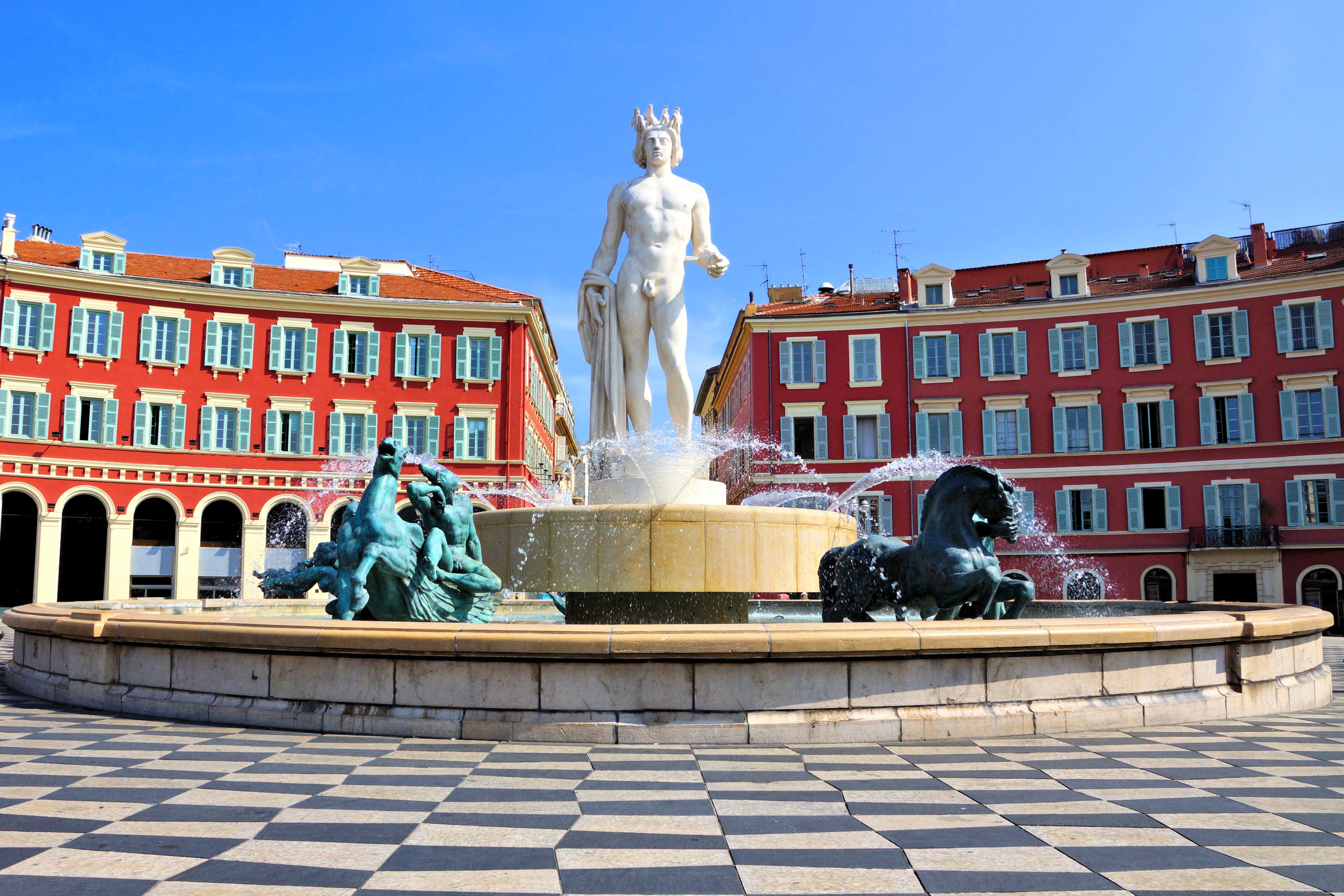 Neptun-statuen og bronzeheste på den berømte fontæne ved Place Massena i Nice på den franske riviera med blå himmel