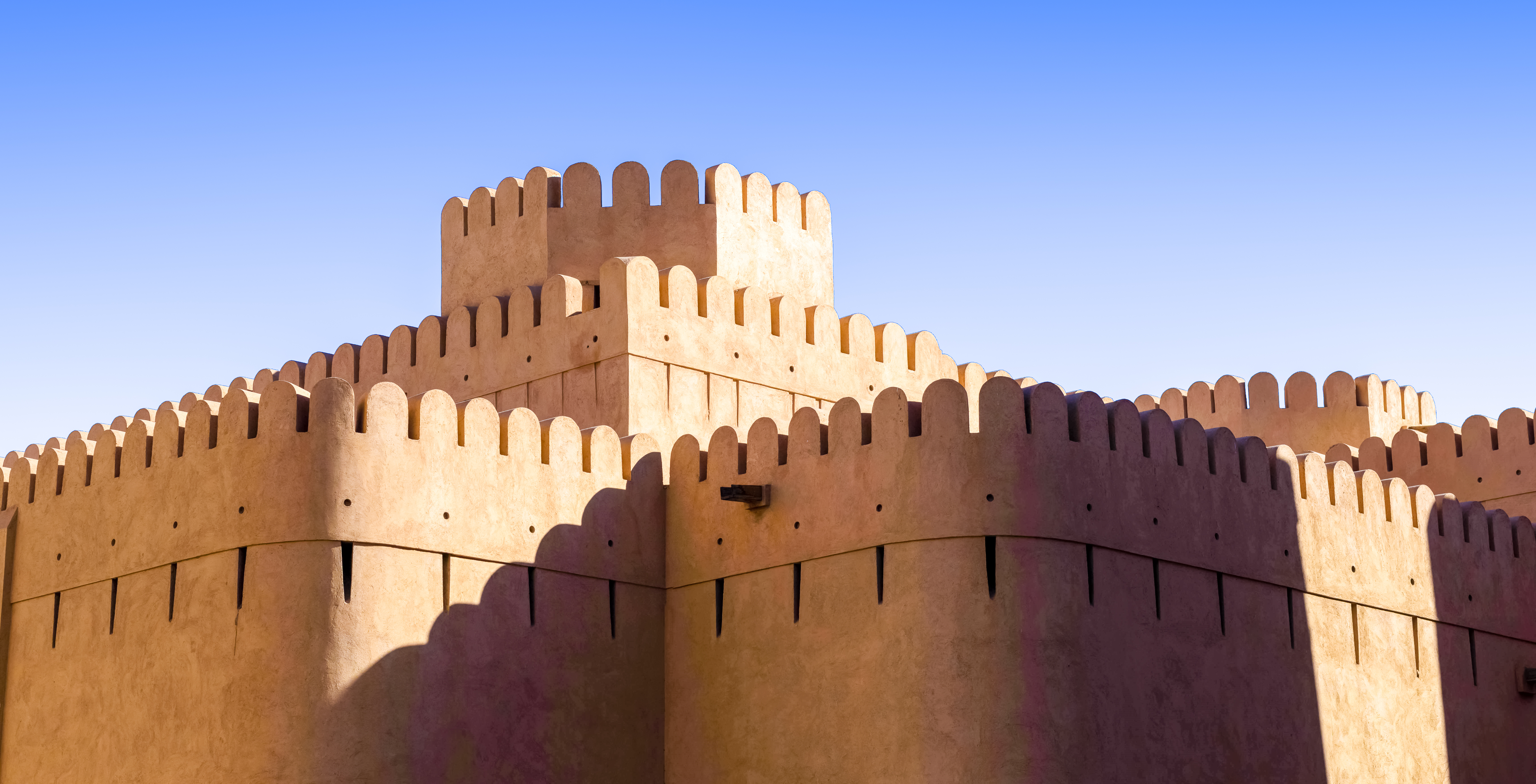 Det storslåede middelalderfort i Nizwa, Oman, med sine markante sandstenstårne og forsvarsværker, en unik kulturel oplevelse på rejser til Den Arabiske Halvø