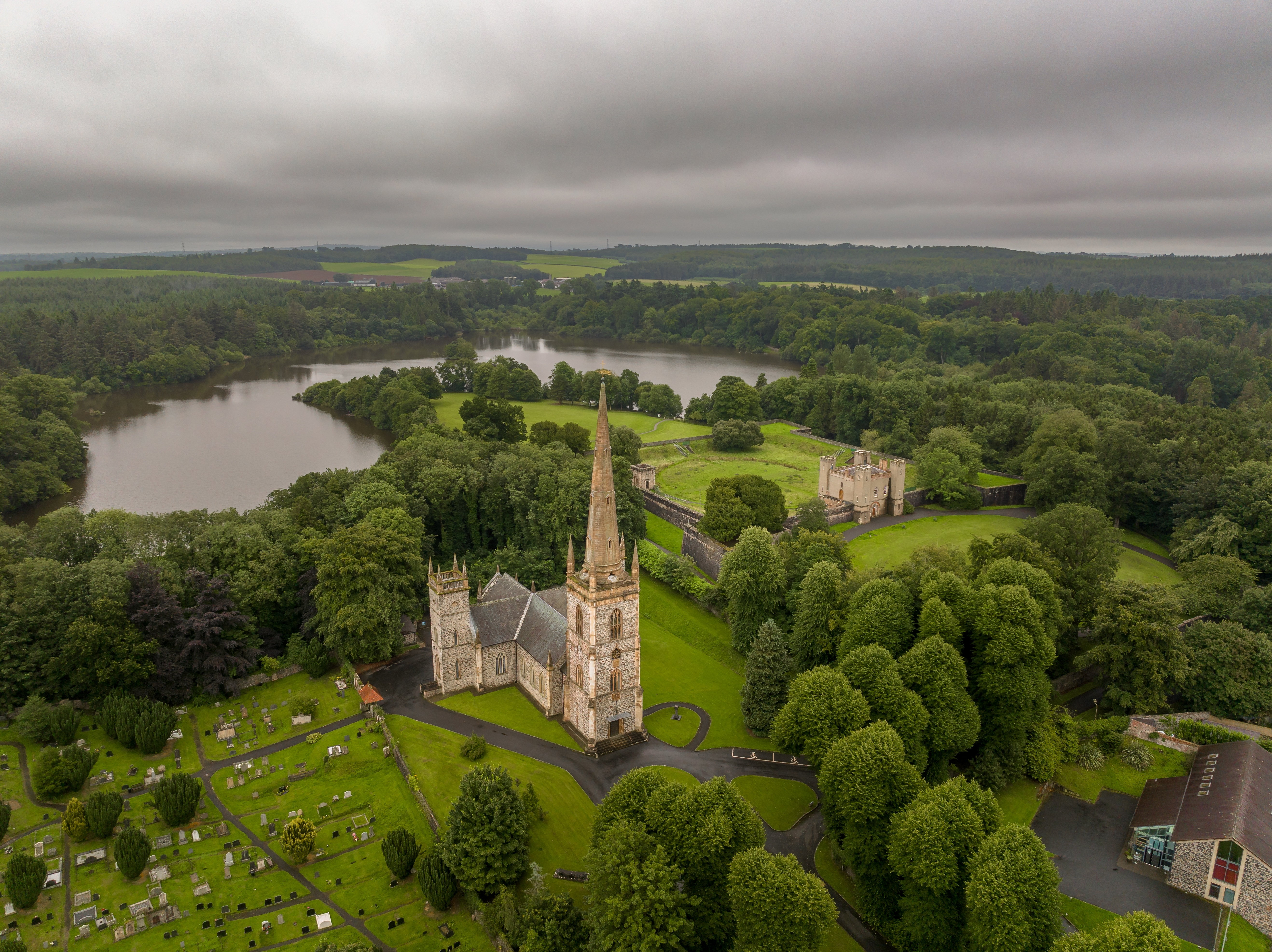 Imponerende kirketårn i frodig nordirsk landskab set fra luften