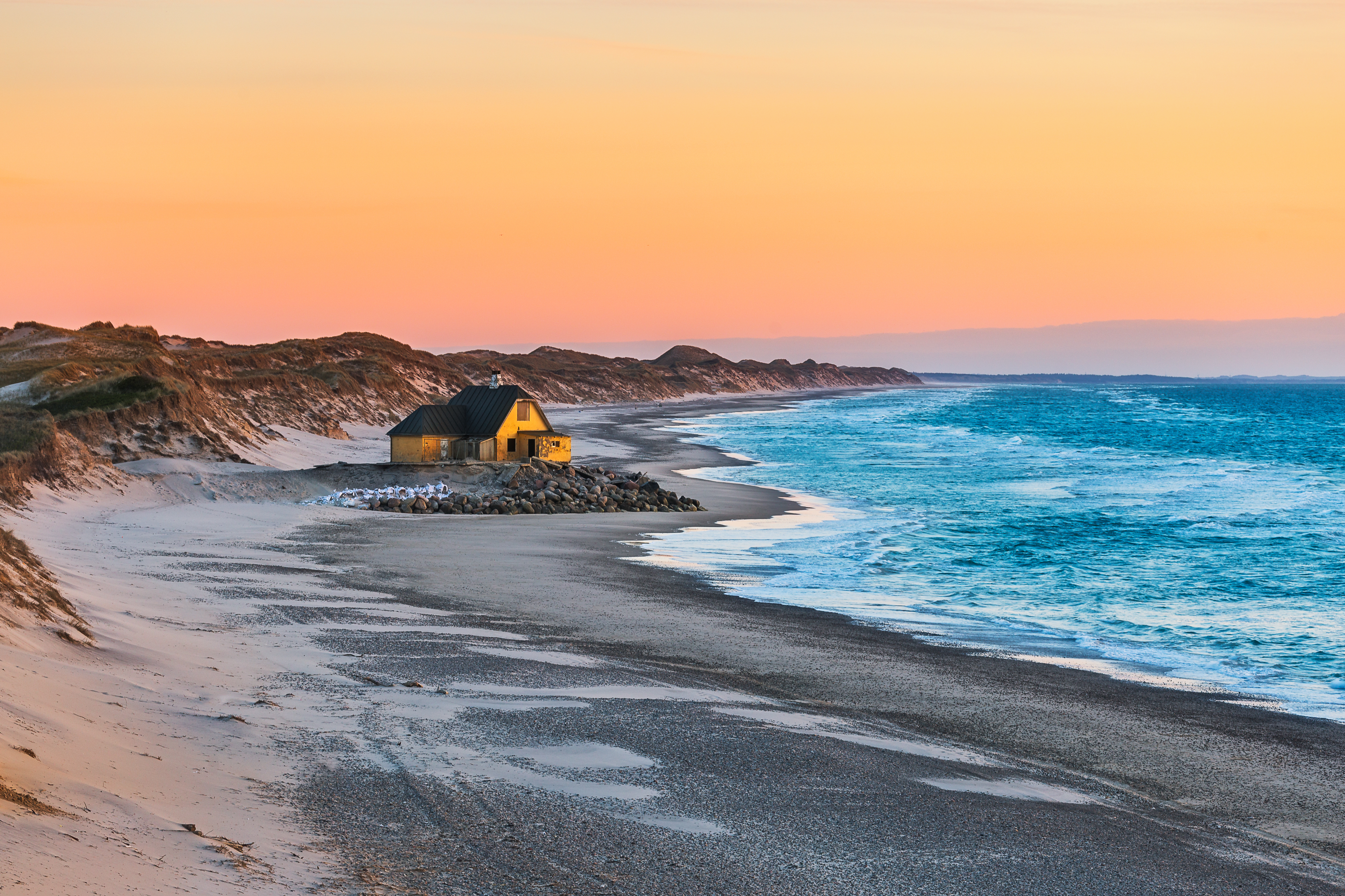 Idyllisk strand cottage i Nordjylland med varmt aftenlys over havet