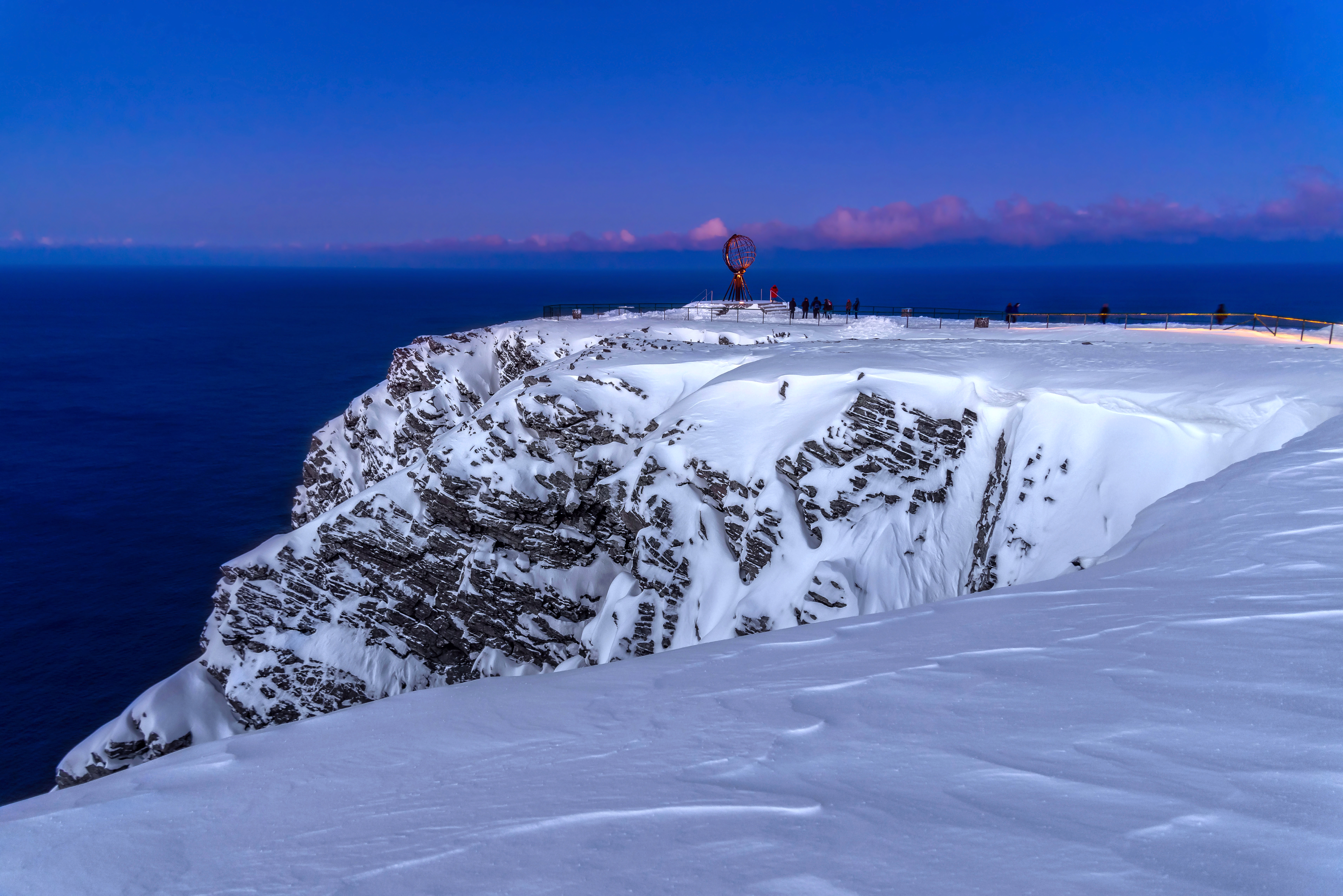 Nordkap Europas nordligste punkt med sne og turister i blå aftenlys Norge