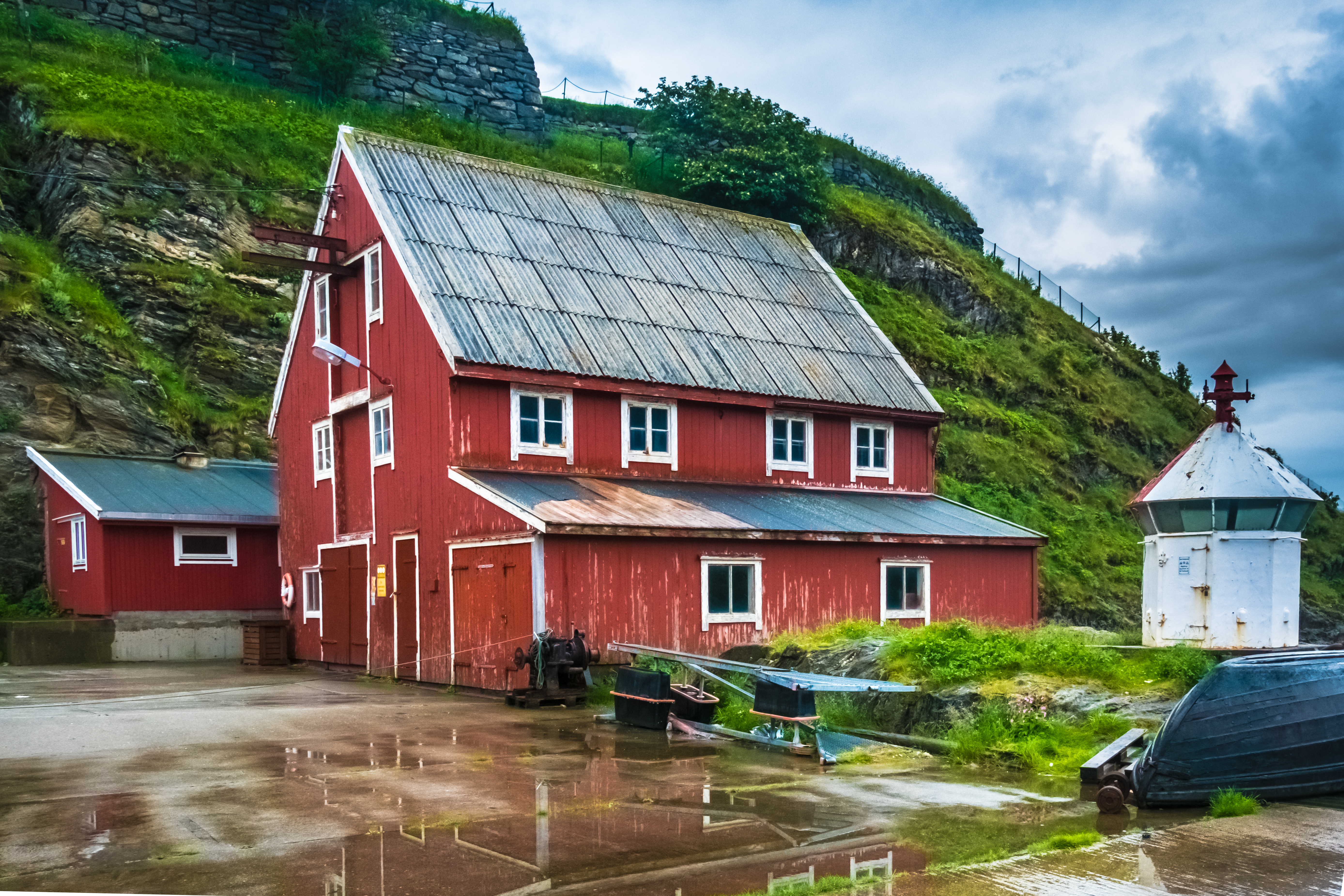 Autentisk norsk fiskerlandsby med røde træhuse ved kysten i Nordland