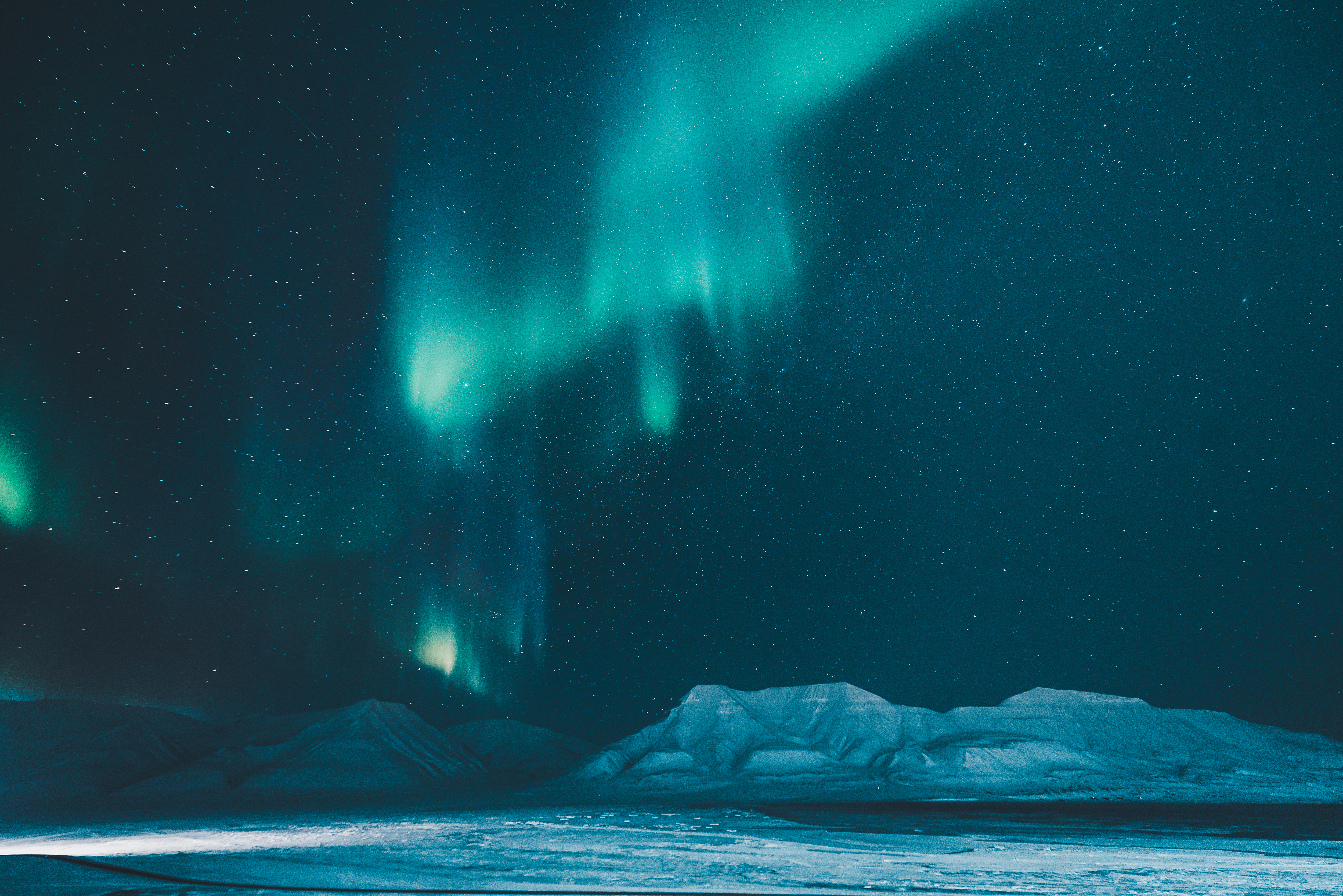 Magiske nordlys over polarlandskab med sne og bjerge i arktisk vinter