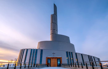 Unik rundformet katedral i Alta Norge med sne og dramatisk himmel