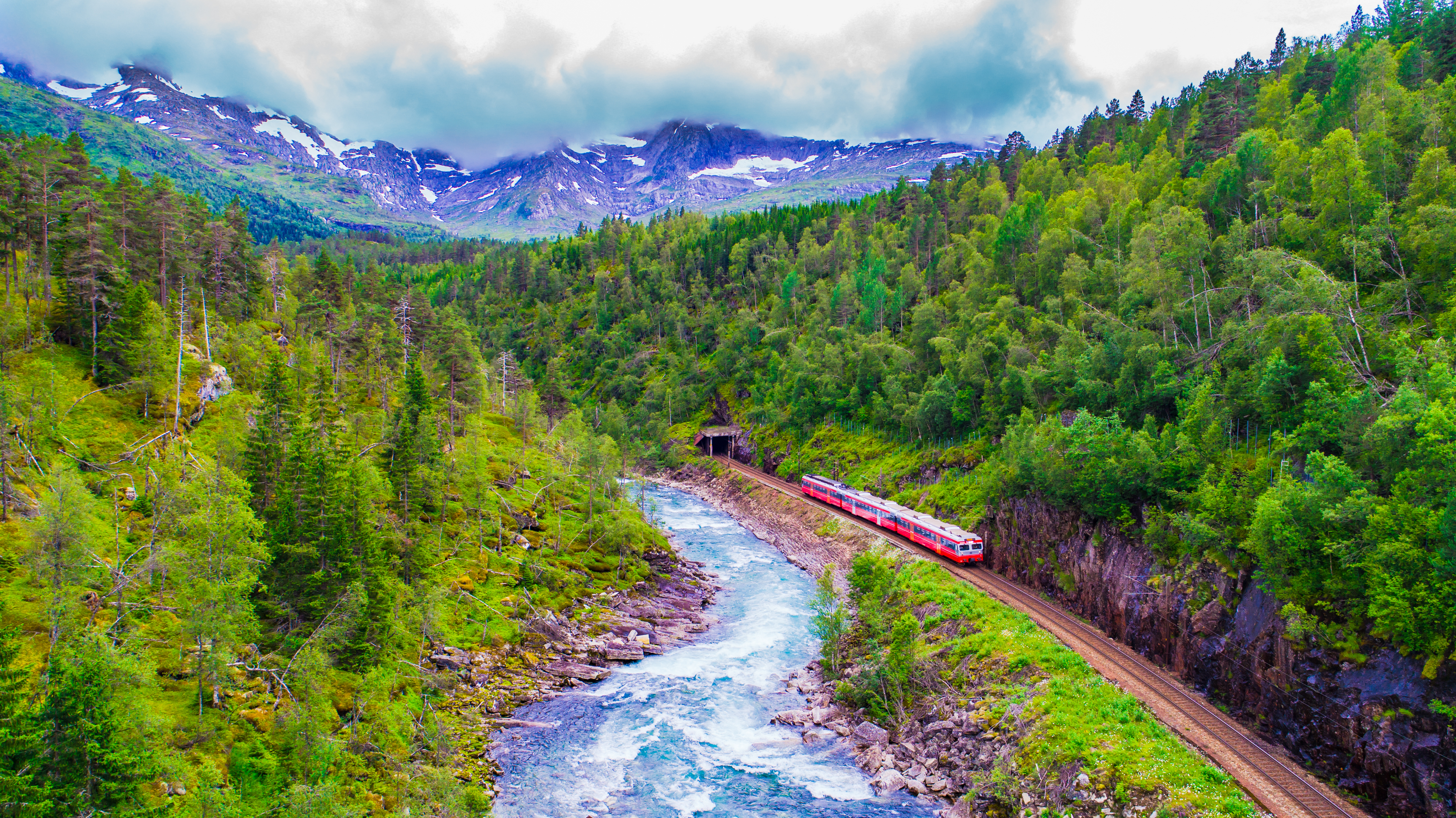 Det røde passagertog på den naturskønne rute mellem Oslo og Bergen, der bringer rejsende gennem Norges storslåede bjerglandskab med tætte skove og blå vandløb