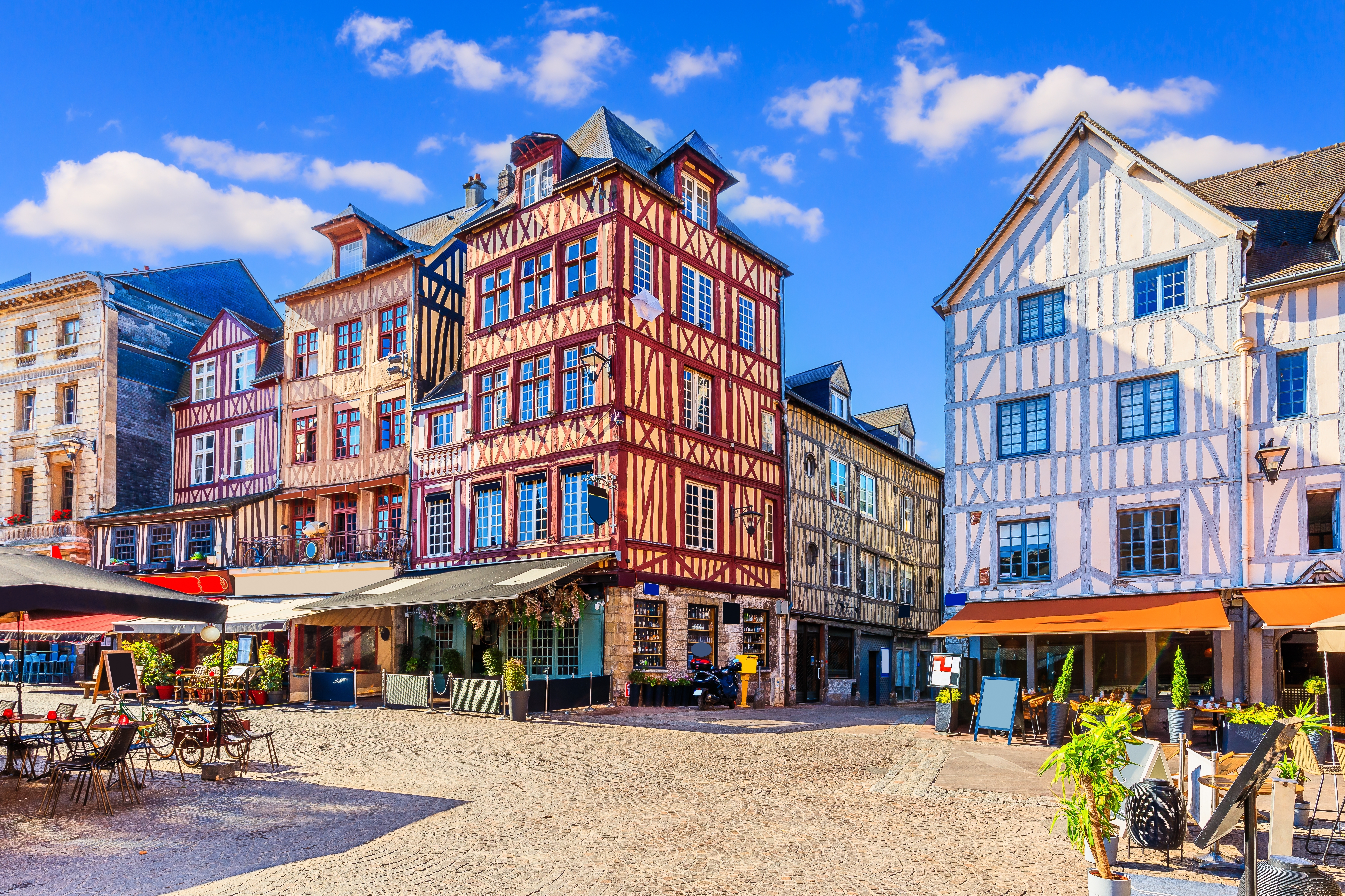 Idyllisk plads med farverige historiske bindingsværksbygninger og udendørs caféer i Rouen, Normandiet