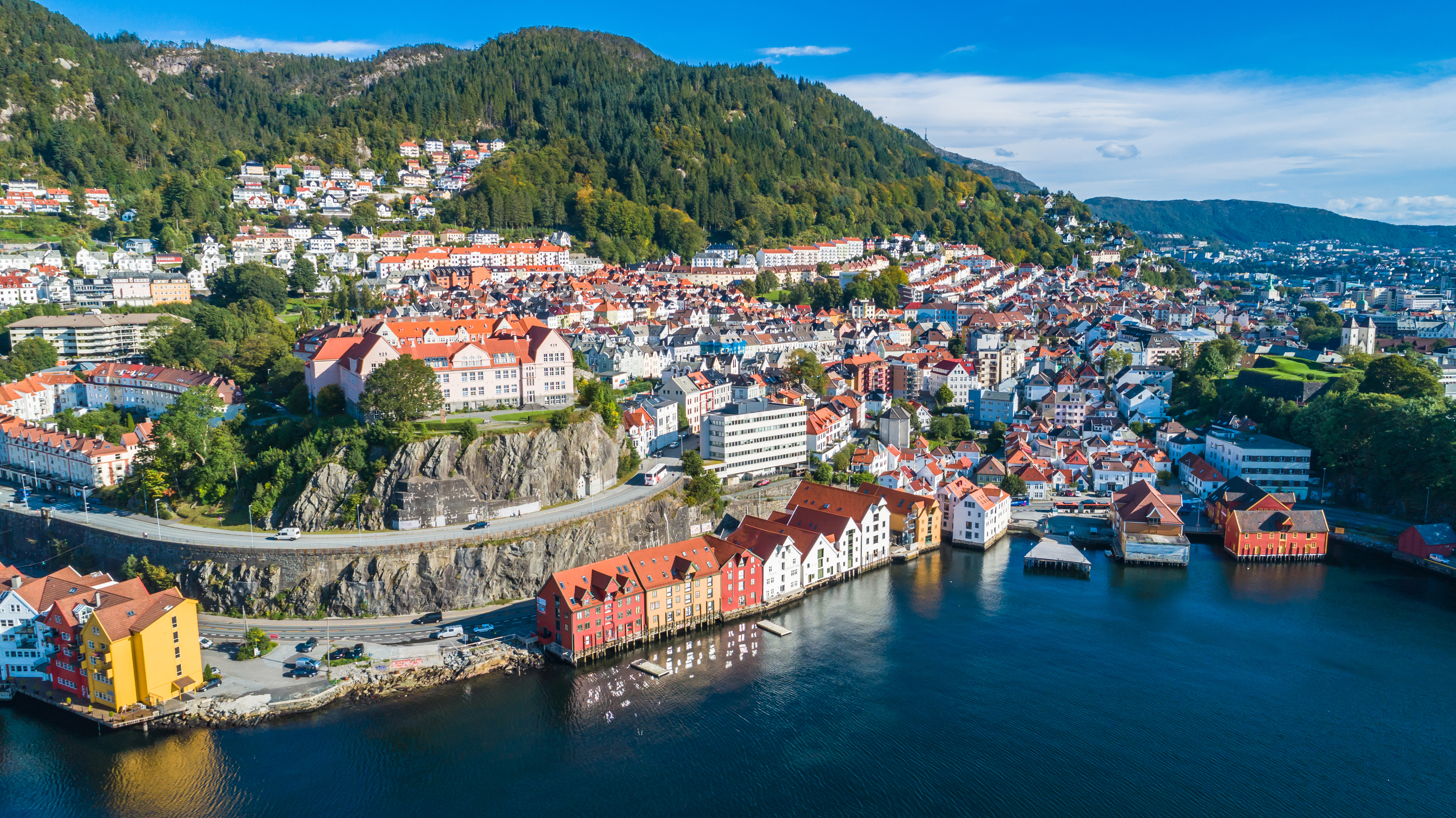 Karakteristiske farverige huse i Bergen Norge ved vandet med fjeldlandskab