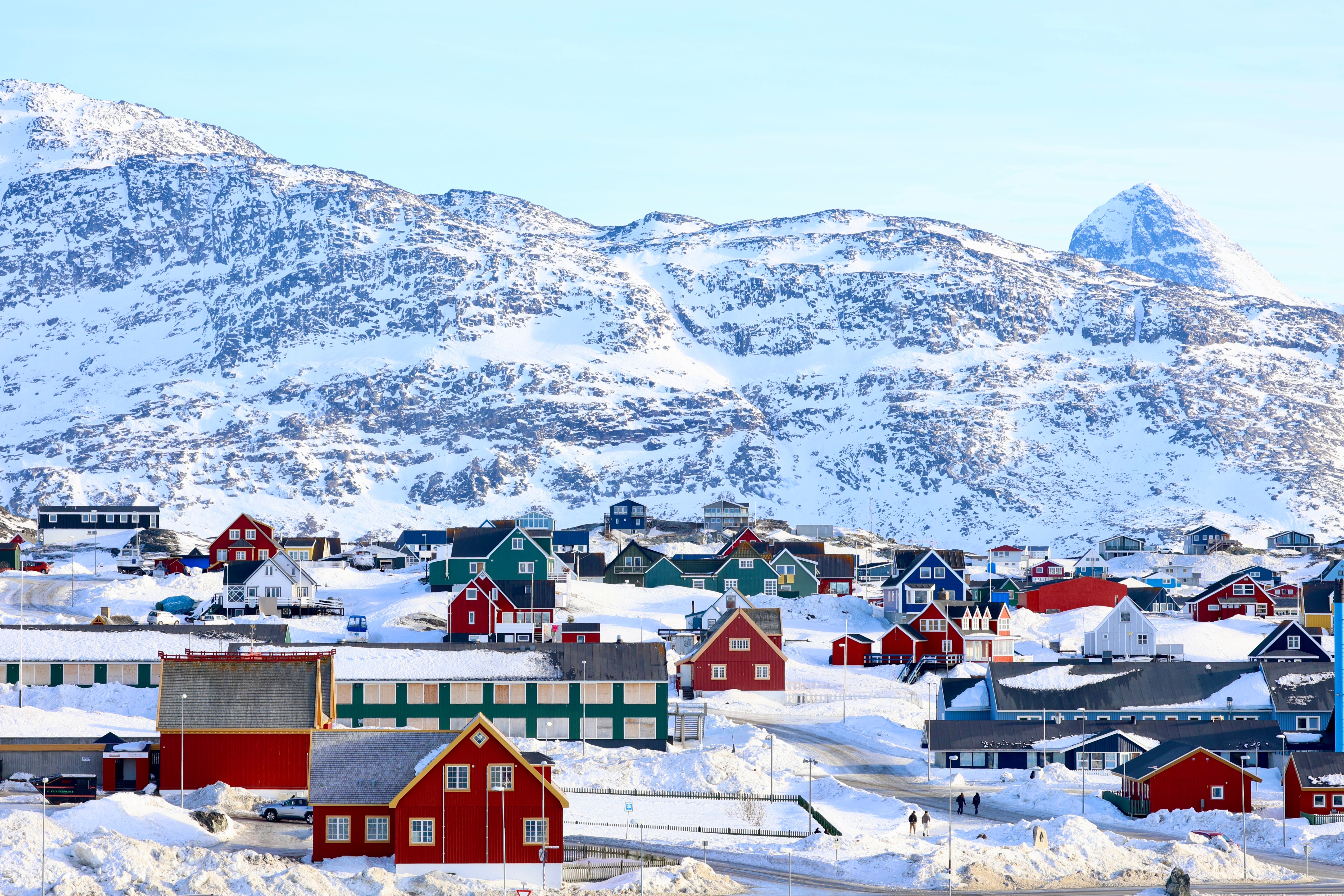 Arktisk vinterbillede af Nuuk by i Grønland med farverige huse og majestætiske snedækkede bjerge