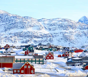 Arktisk vinterbillede af Nuuk by i Grønland med farverige huse og majestætiske snedækkede bjerge